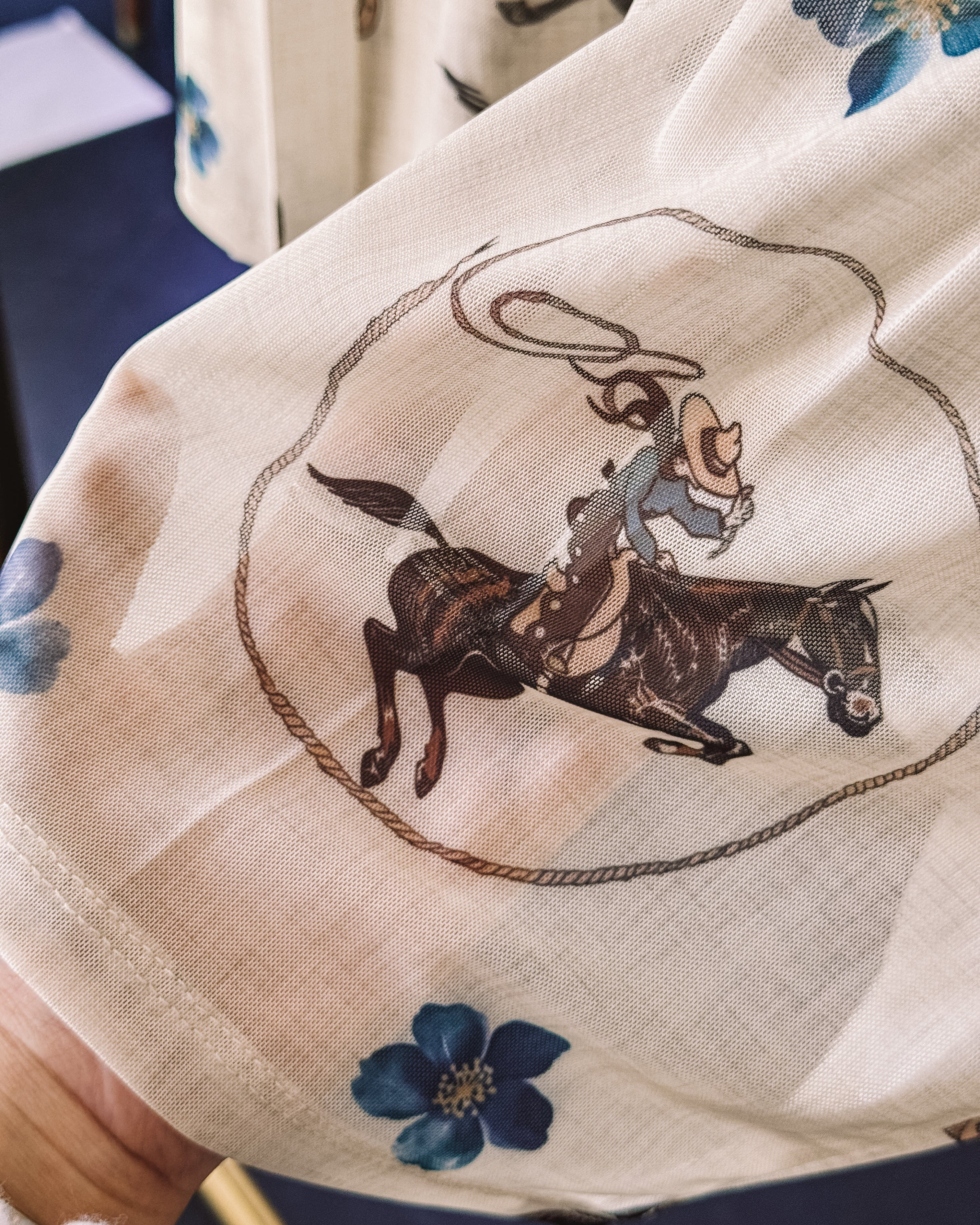 Thunderbird pendant chain necklace displayed on wooden slab with serape fabric underneath - The Wild J