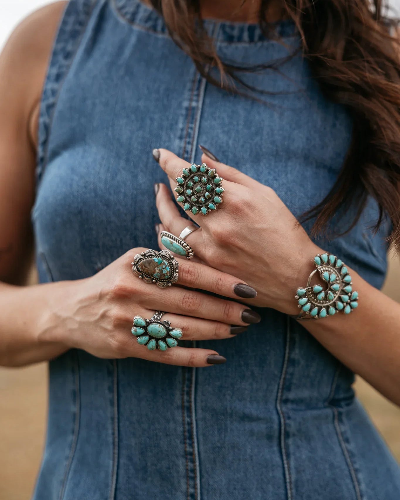Woman in denim dress wearing western turquoise rings and boho jewelry