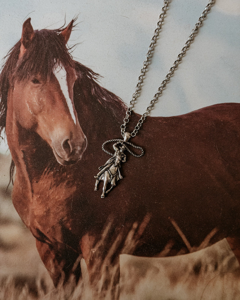 Western cowgirl pendant necklace displayed on background with brown horse, boho jewelry