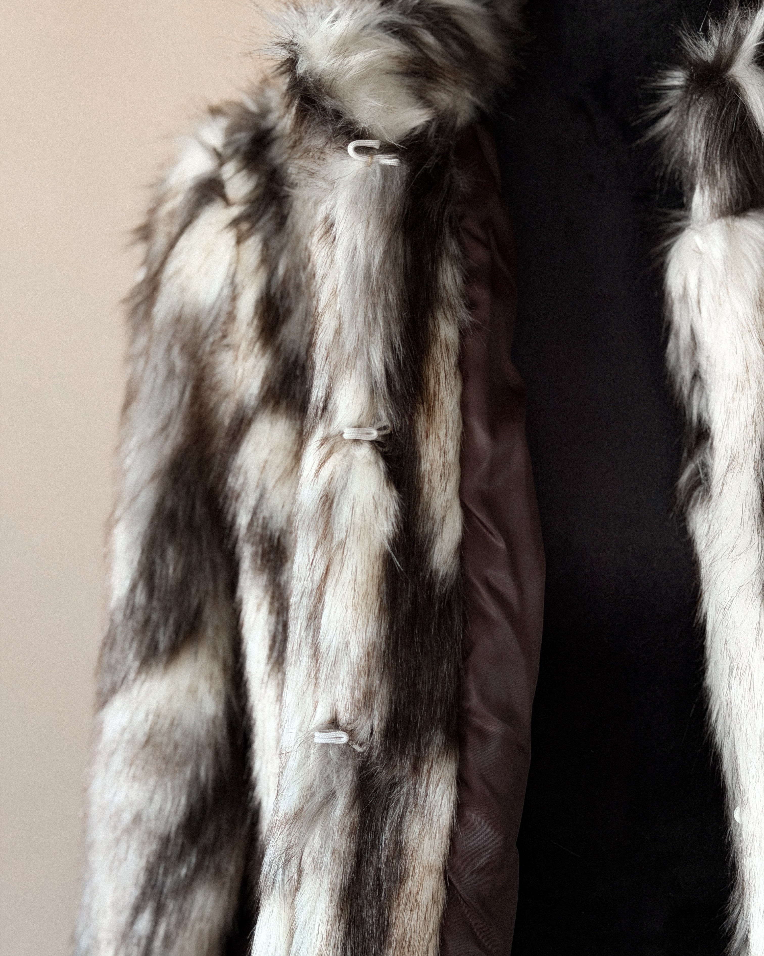 Brown and white faux fur western jacket with toggle closures on a mannequin