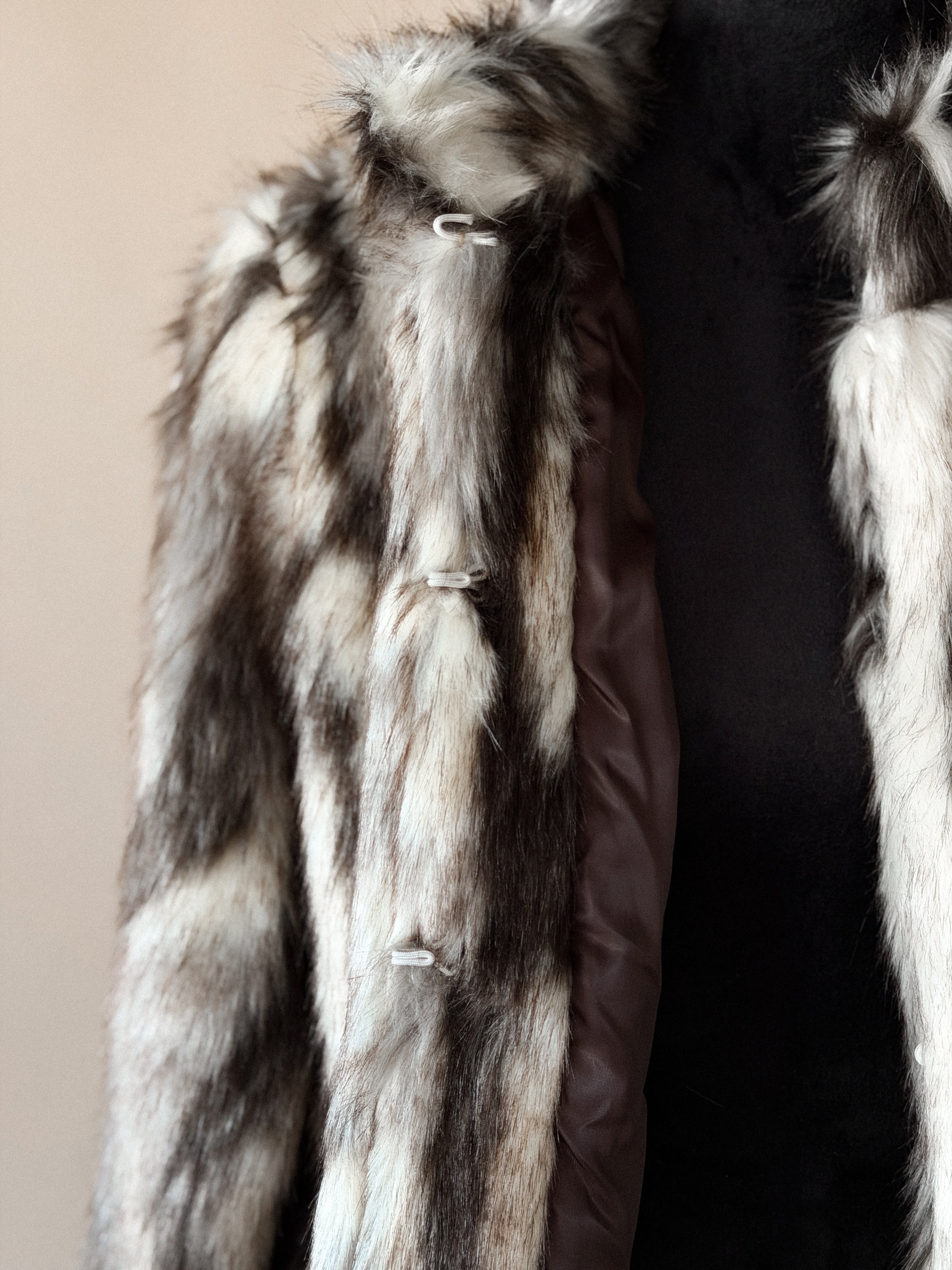 Brown and white faux fur western jacket with toggle closures on a mannequin