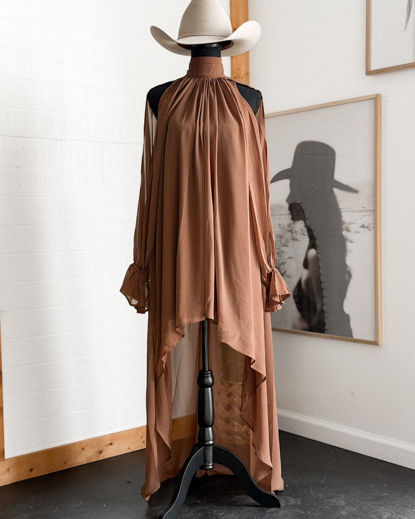 Brown western high-low dress with ruffled sleeves on mannequin, styled with cowboy hat