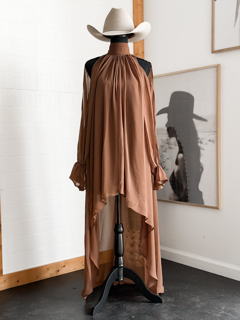 Brown western high-low dress with ruffled sleeves on mannequin, styled with cowboy hat