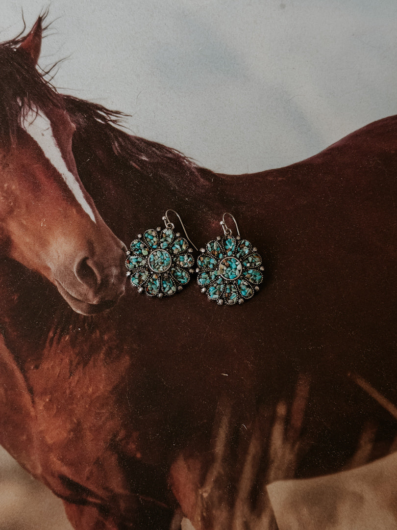 Thunderbird pendant chain necklace displayed on wooden slab with serape fabric underneath - The Wild J