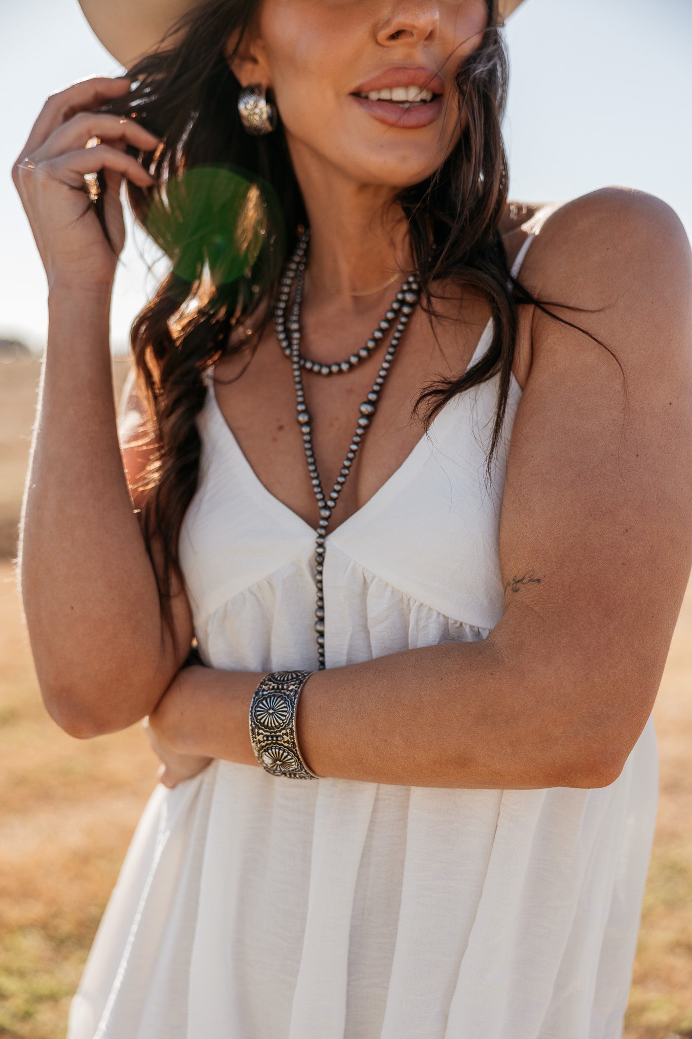 Thunderbird pendant chain necklace displayed on wooden slab with serape fabric underneath - The Wild J