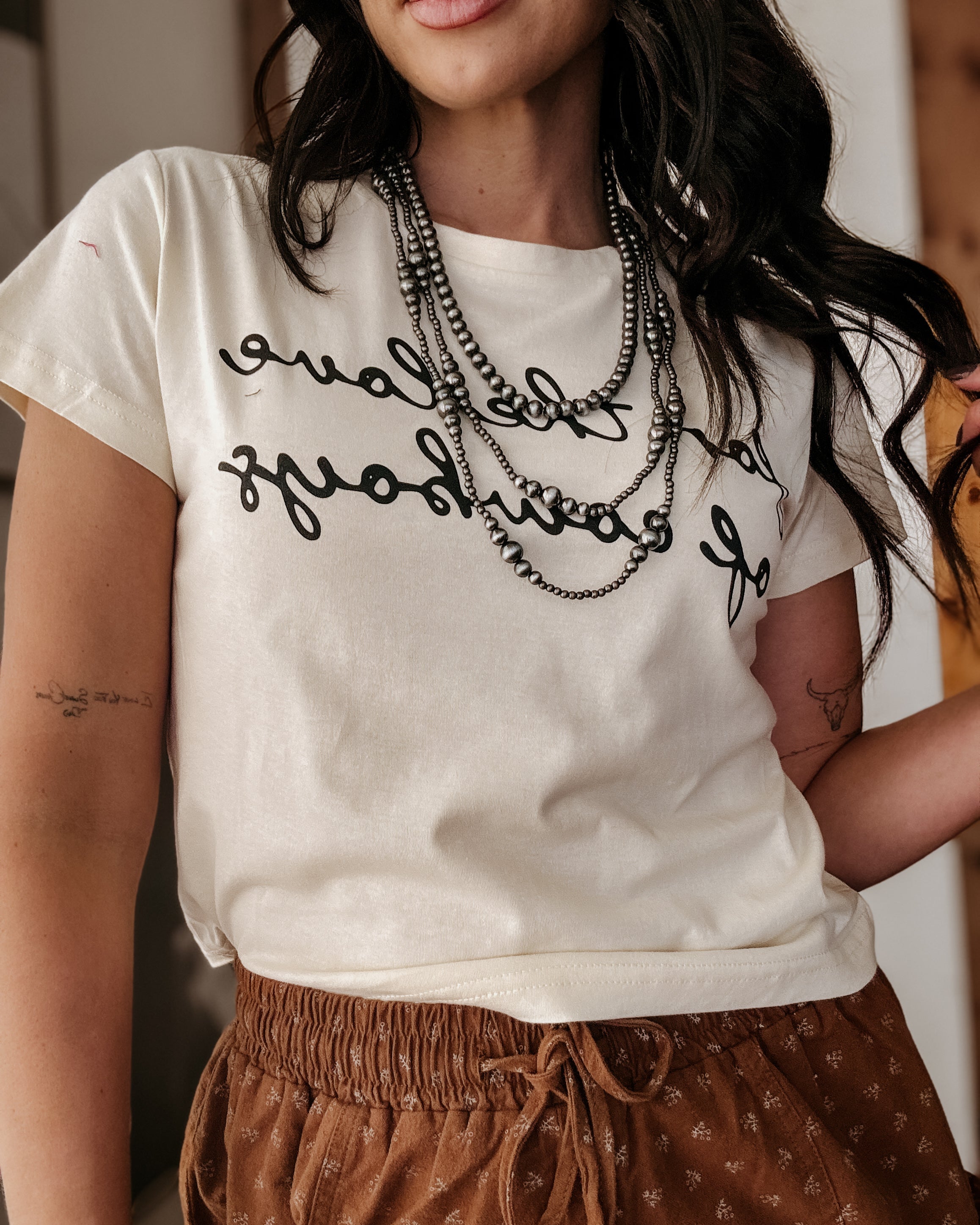 Thunderbird pendant chain necklace displayed on wooden slab with serape fabric underneath - The Wild J