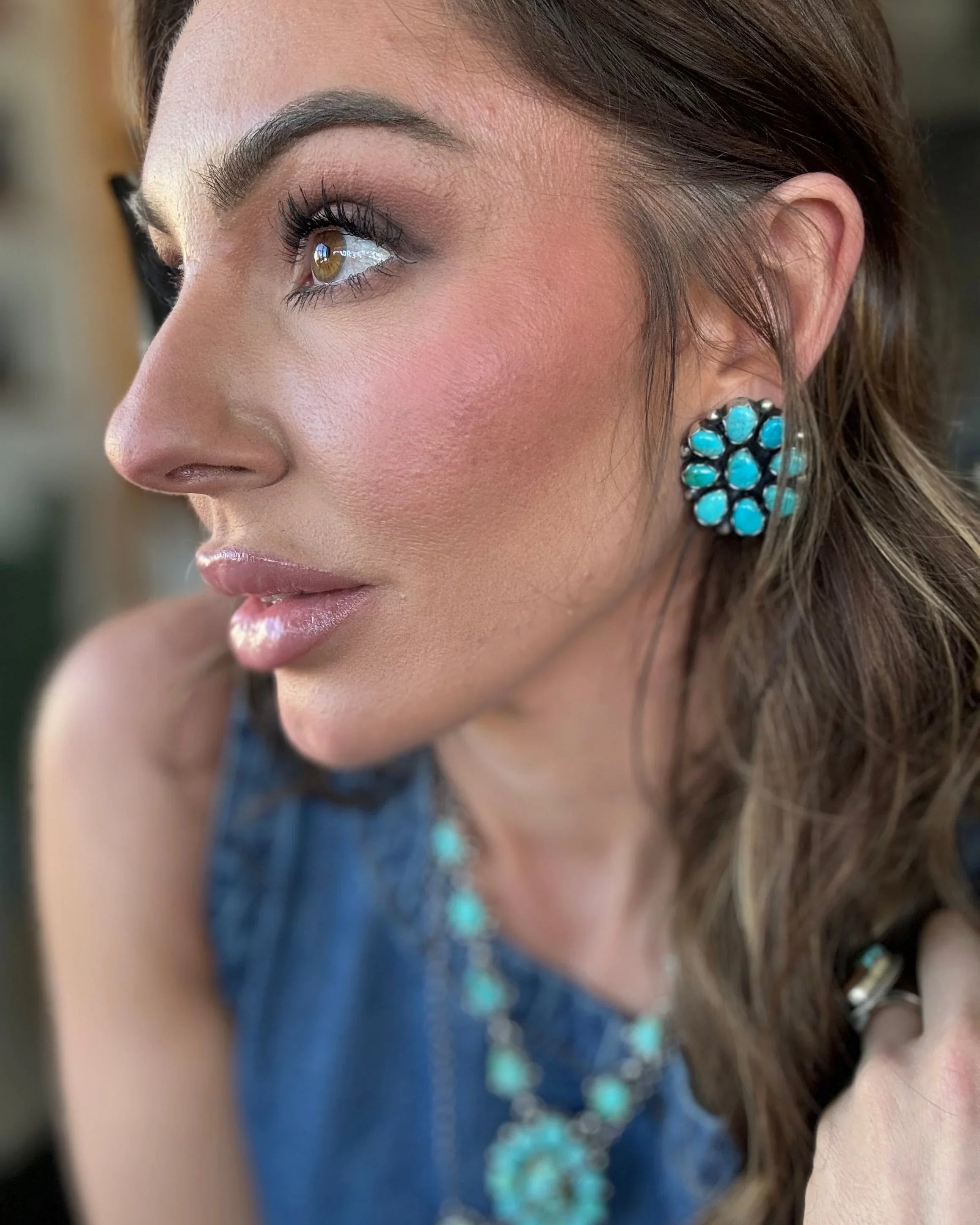 Woman wearing turquoise western earrings, necklace and ring, styled in boho cowgirl fashion