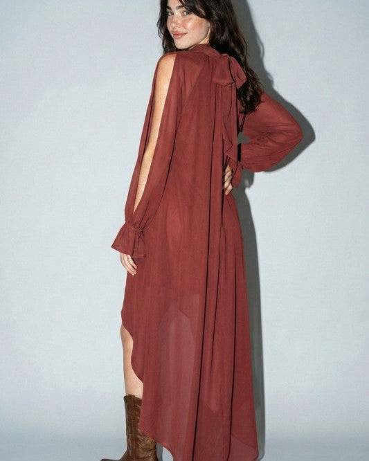 Woman in western boho high-low rust dress with open sleeves and brown cowboy boots