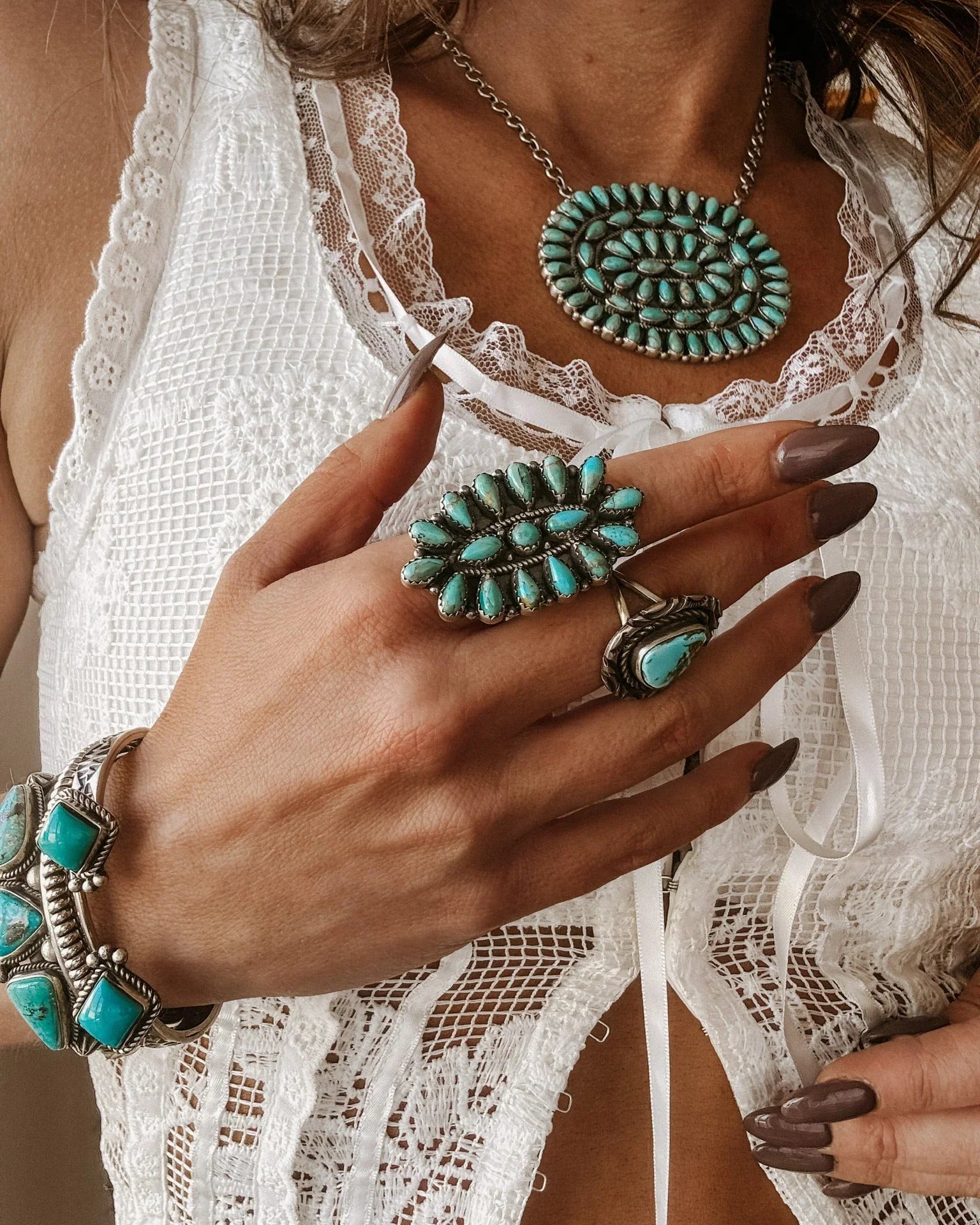 Woman wearing boho western turquoise jewelry set with lace white top, showcasing necklace, ring, and bracelet.