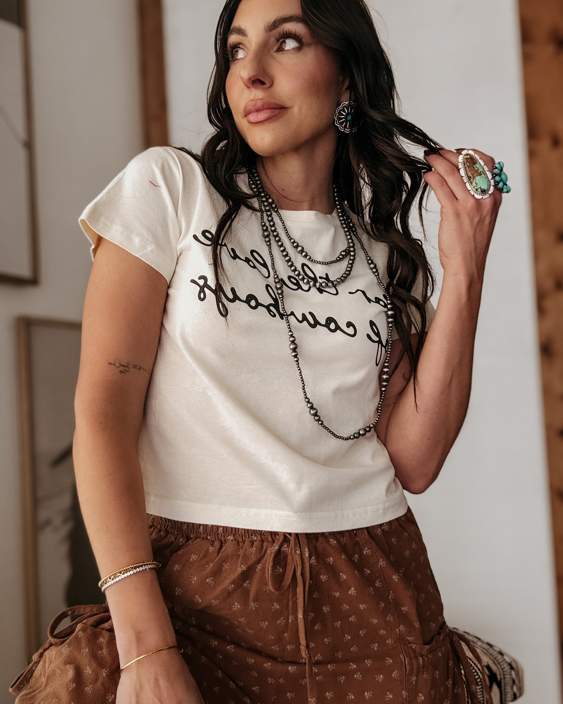 Thunderbird pendant chain necklace displayed on wooden slab with serape fabric underneath - The Wild J