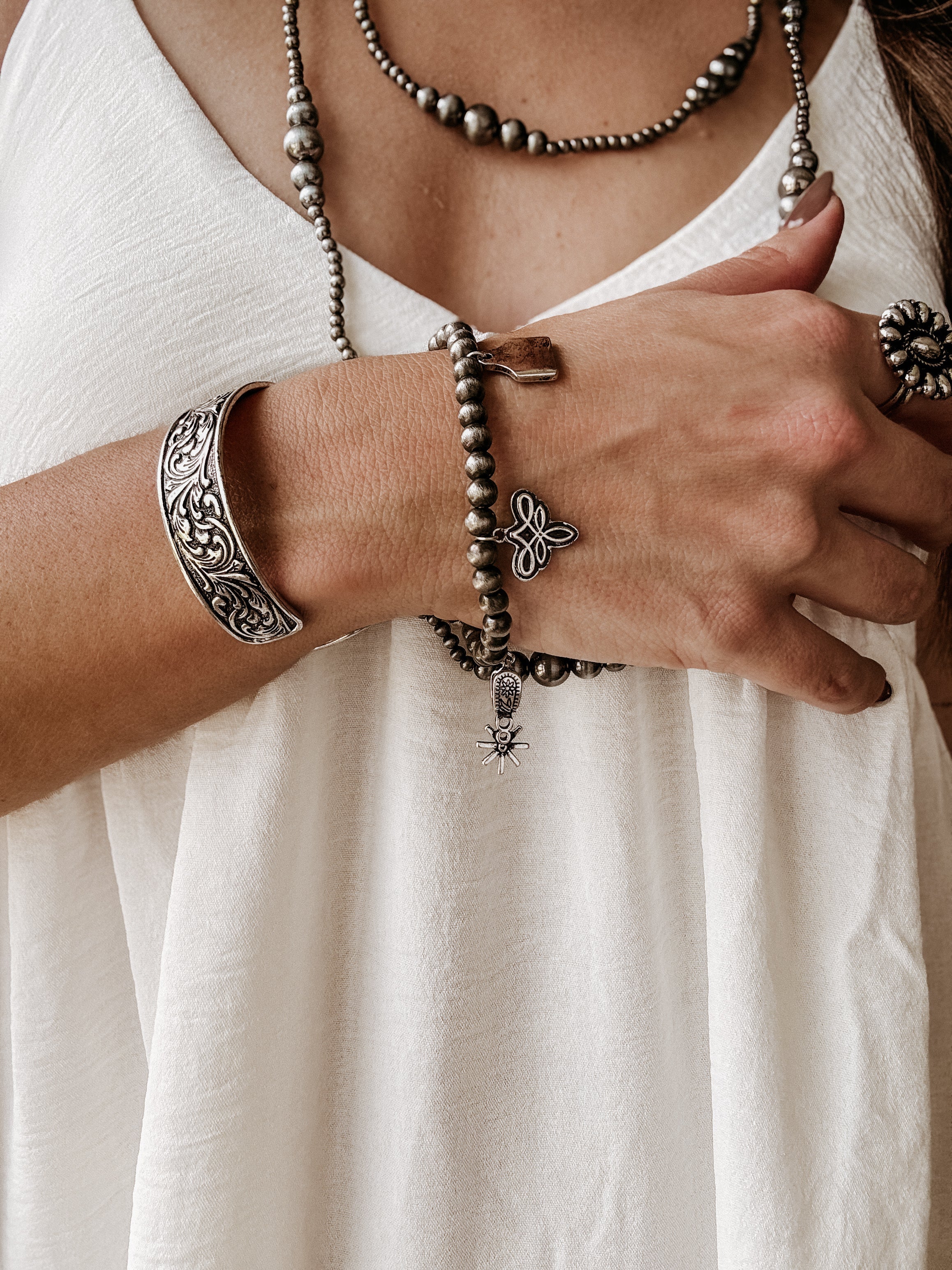 Thunderbird pendant chain necklace displayed on wooden slab with serape fabric underneath - The Wild J