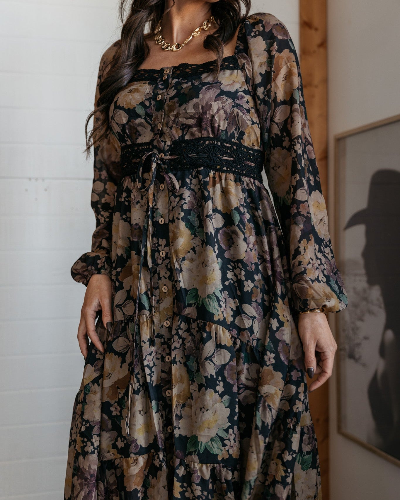 Woman in a boho western floral maxi dress with long sleeves and black lace belt