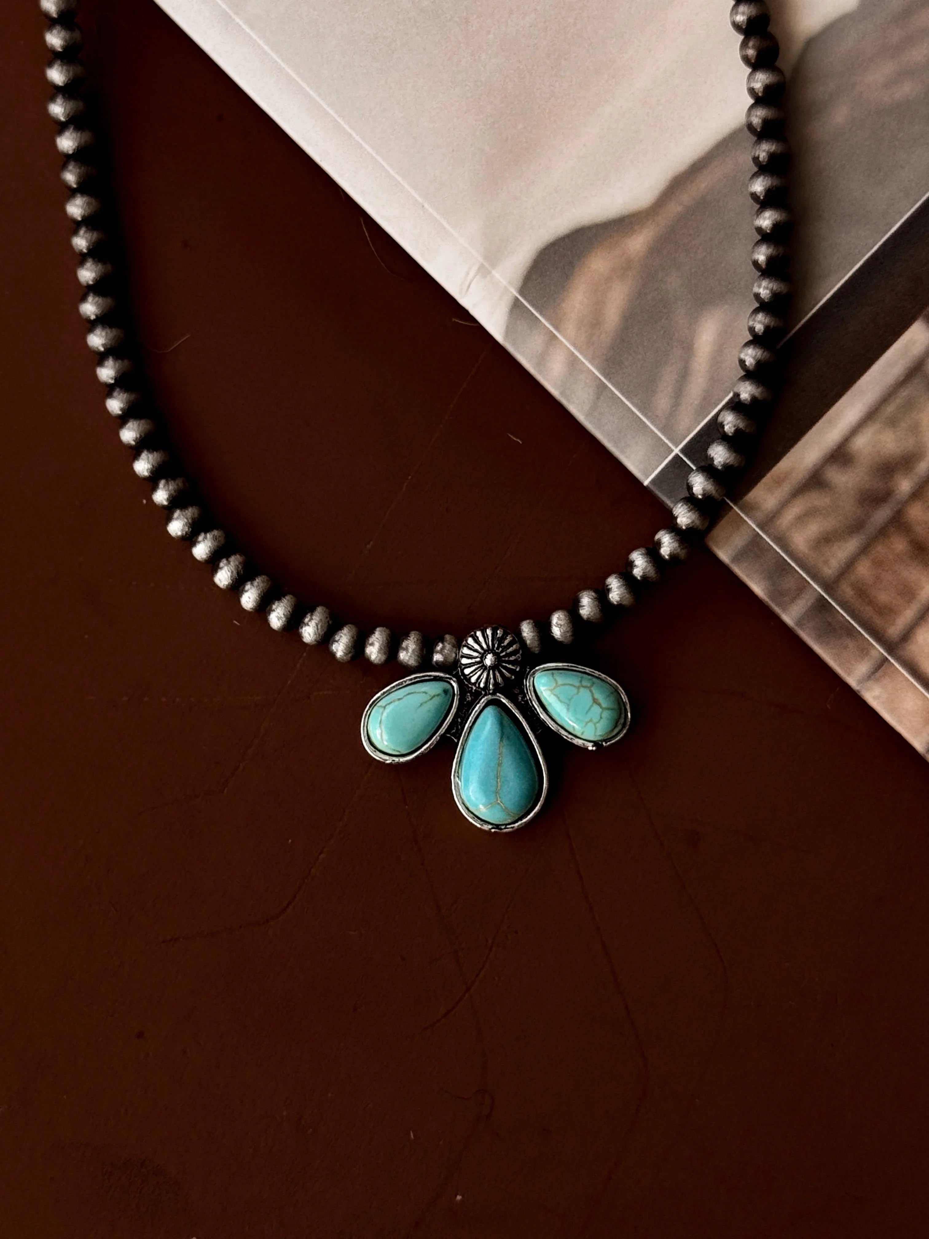 Necklace with turquoise pendants on a brown surface
