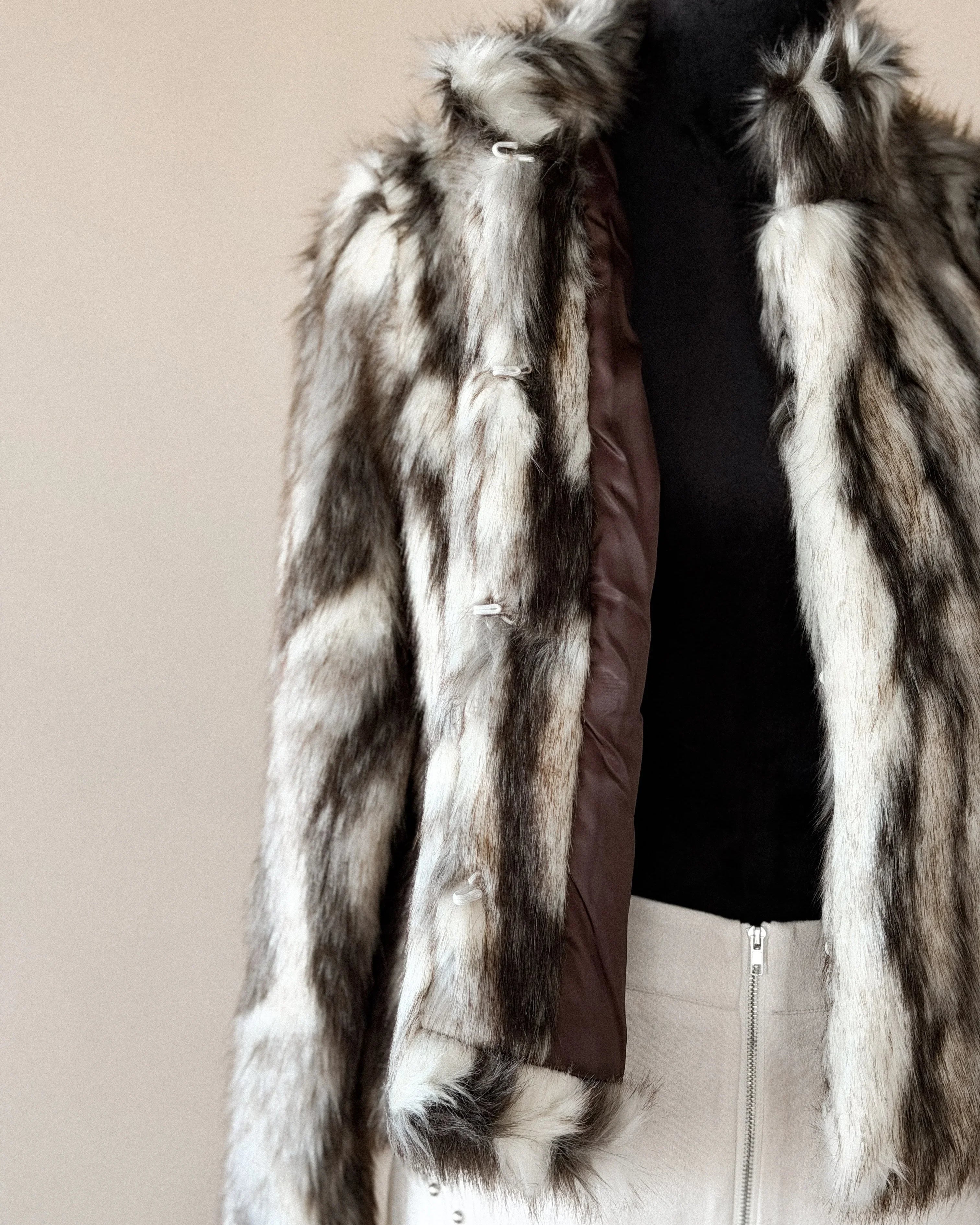 Western faux fur jacket with brown and white stripes, paired with a studded cream skirt.
