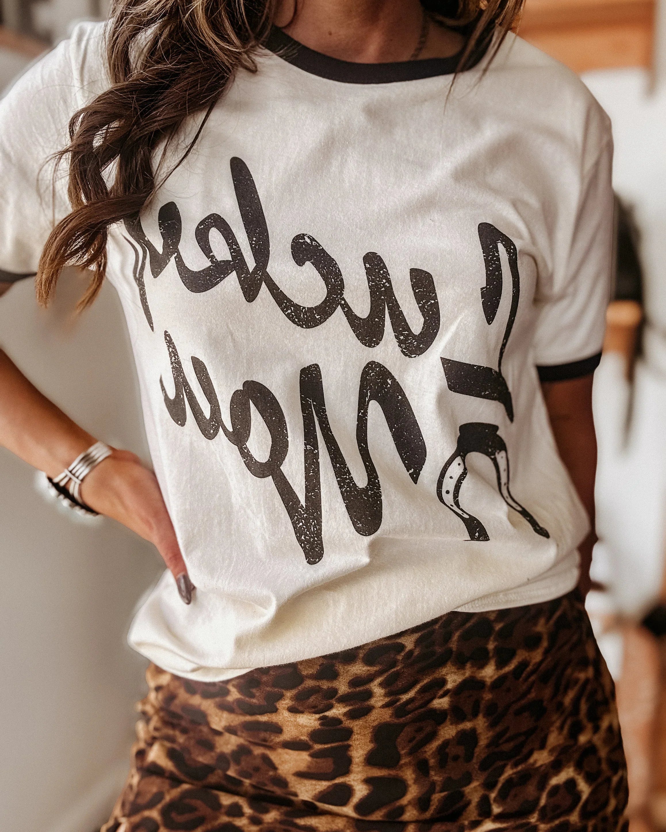 Woman wearing western graphic t-shirt and leopard print skirt, western boho outfit style