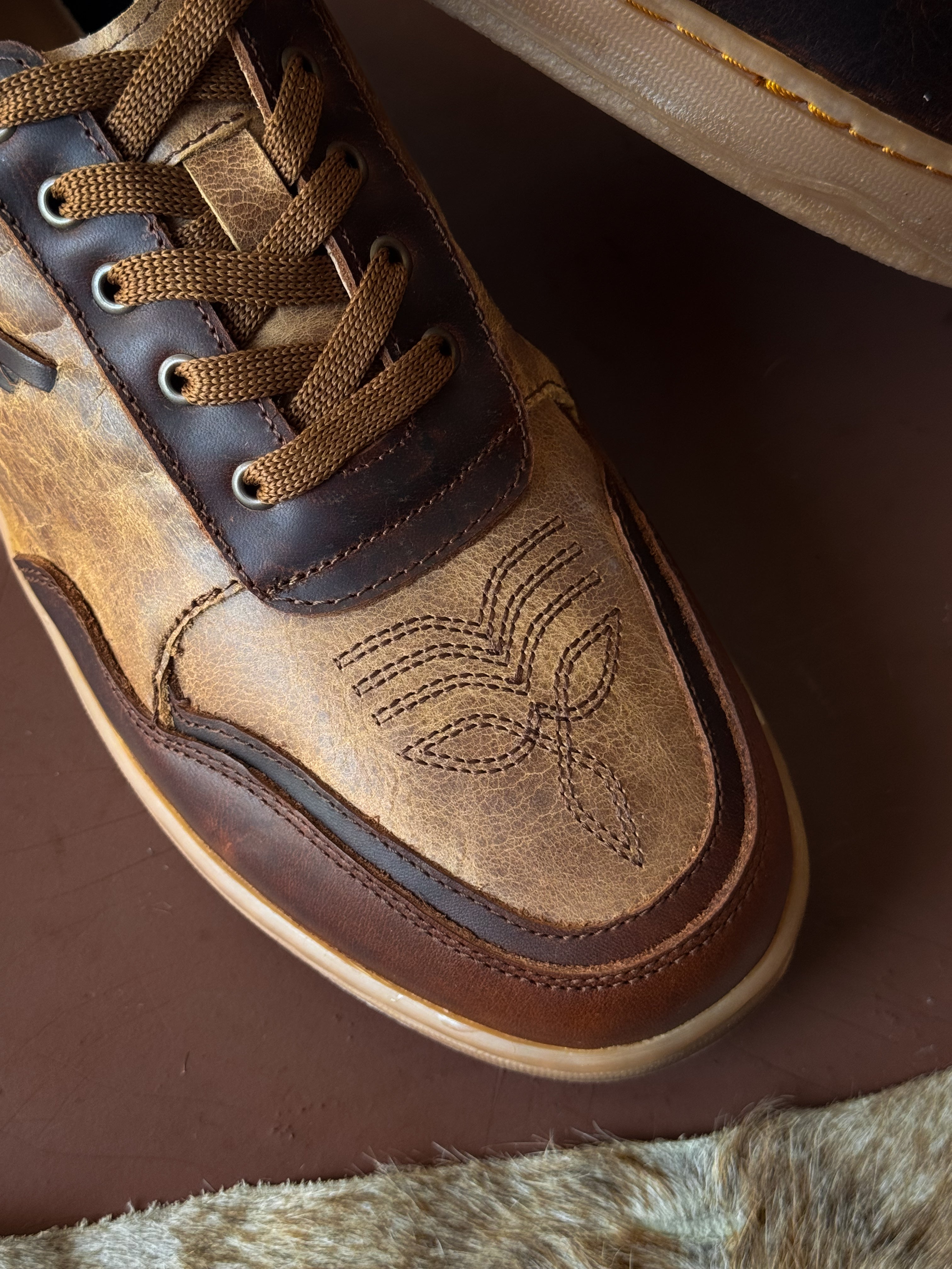 Brown leather western sneaker with stitched toe design, western boho footwear detail