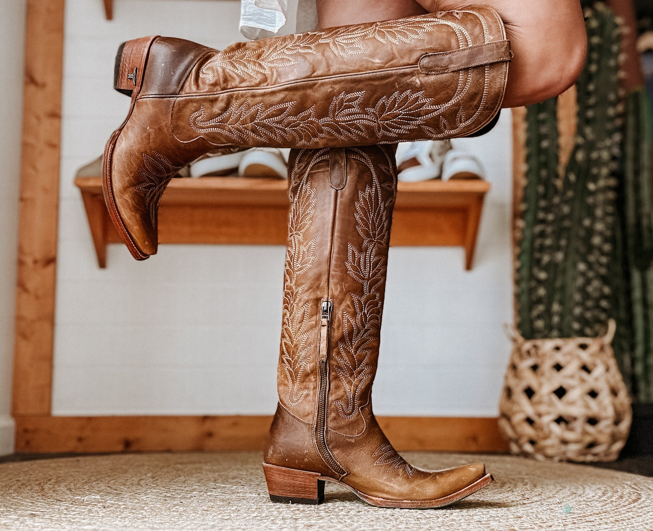 Brown tooled leather western cowgirl boots with embroidery, side zipper, and pointed toe