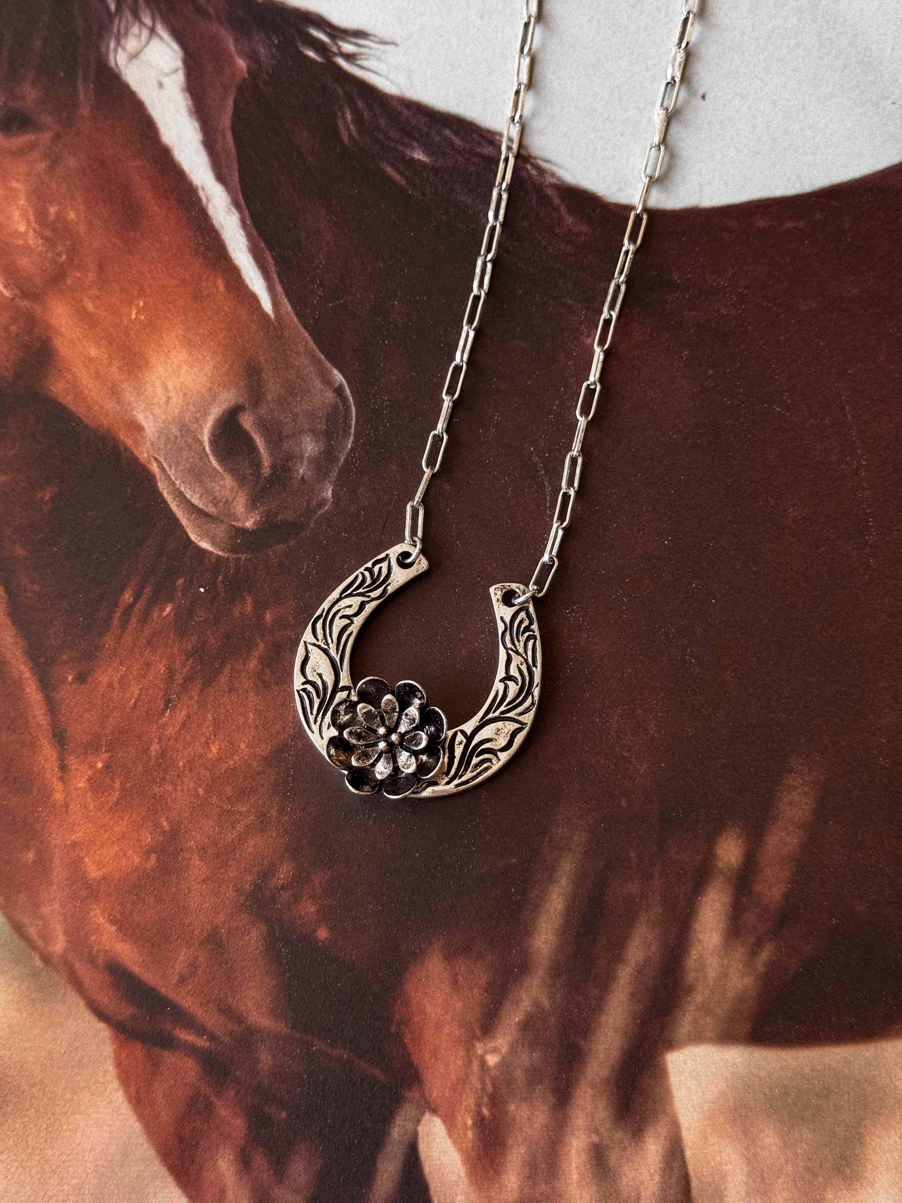 Thunderbird pendant chain necklace displayed on wooden slab with serape fabric underneath - The Wild J