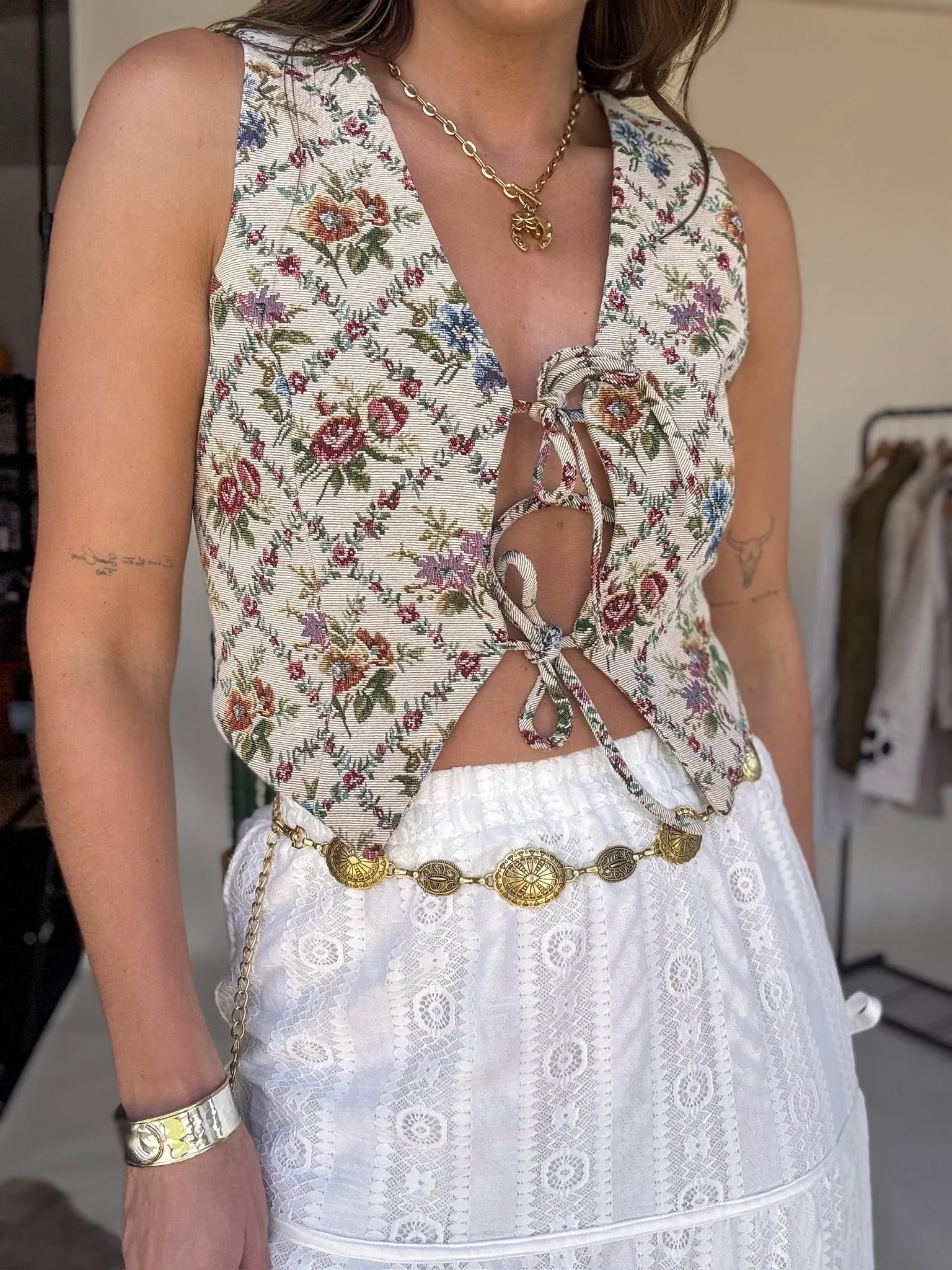 Woman wearing a floral top and white skirt with a blurred background