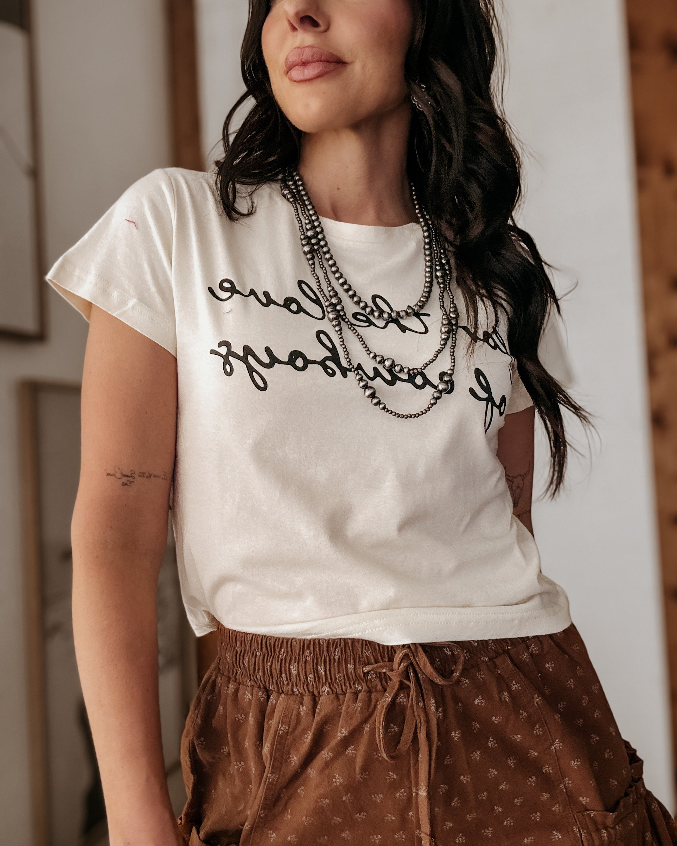 Thunderbird pendant chain necklace displayed on wooden slab with serape fabric underneath - The Wild J