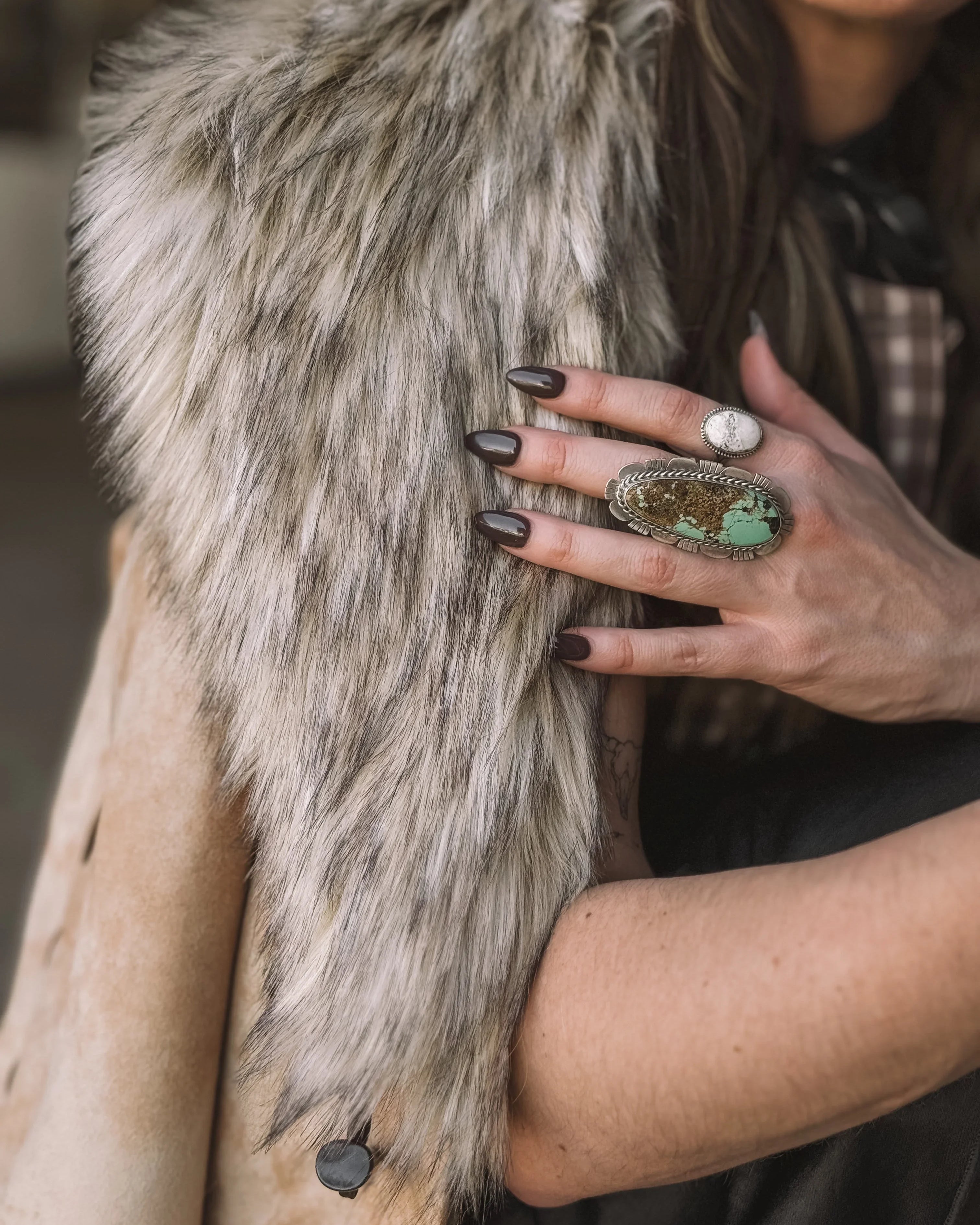 Woman wearing faux fur western vest and turquoise statement ring, western boho style