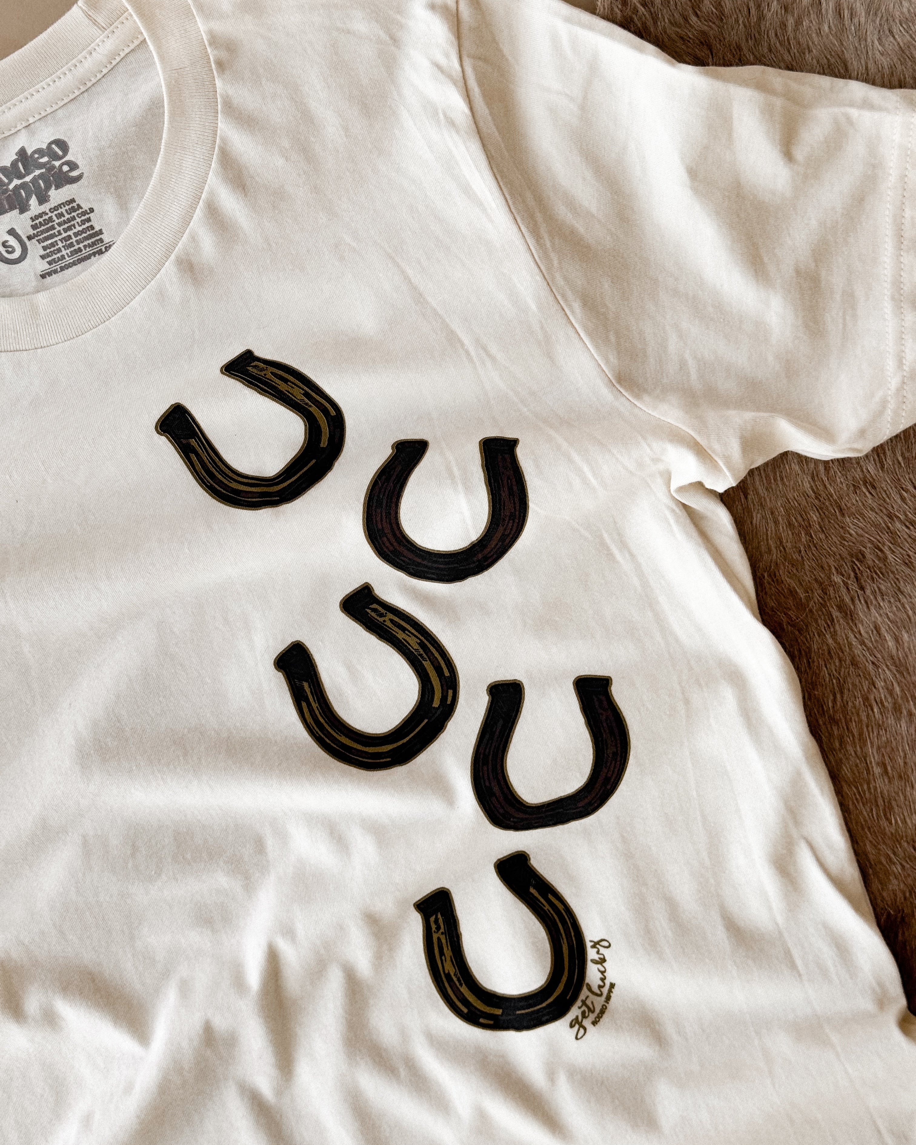 White western graphic t-shirt with black horseshoe prints, boho cowgirl outfit style