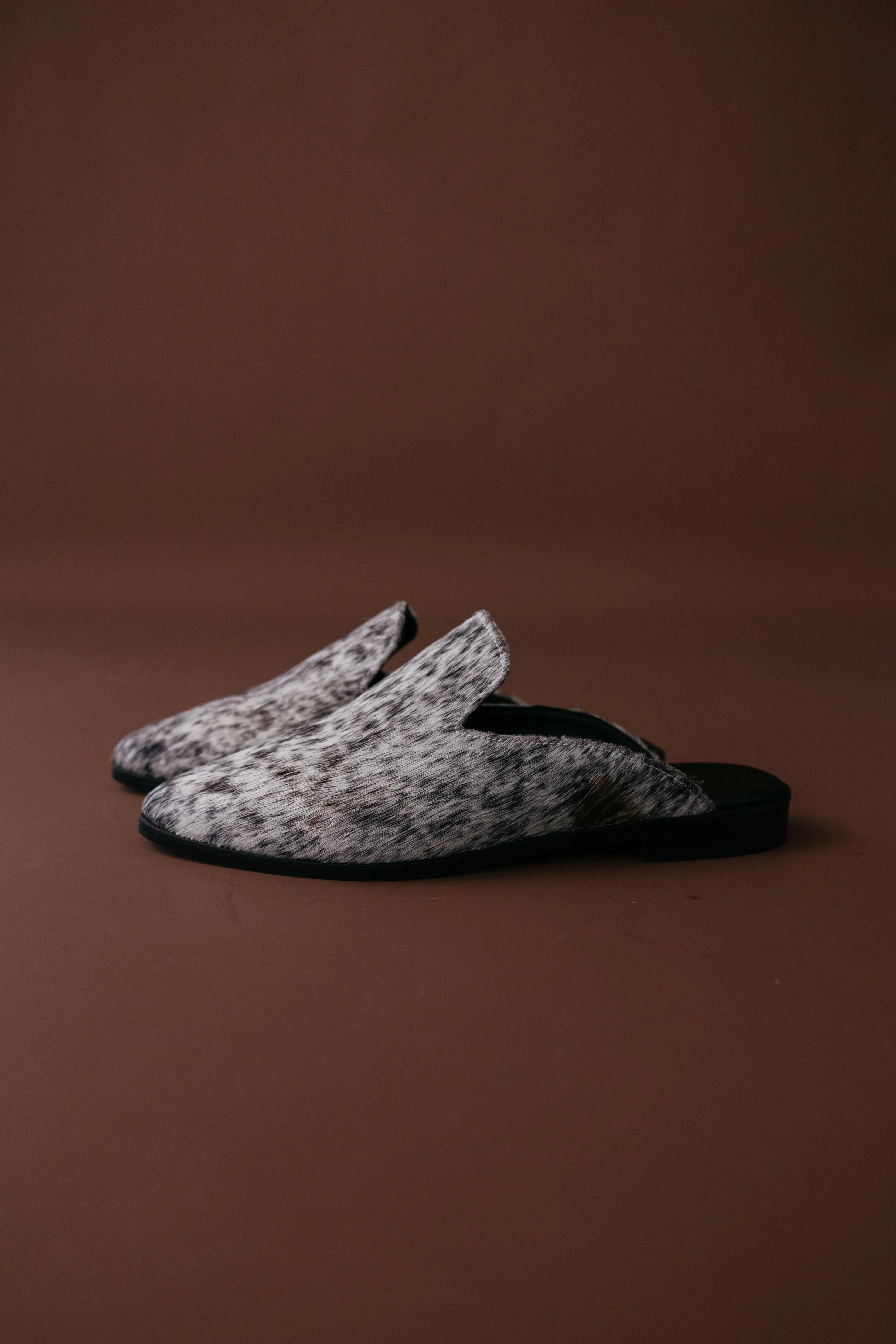 Pair of gray slippers on a brown background