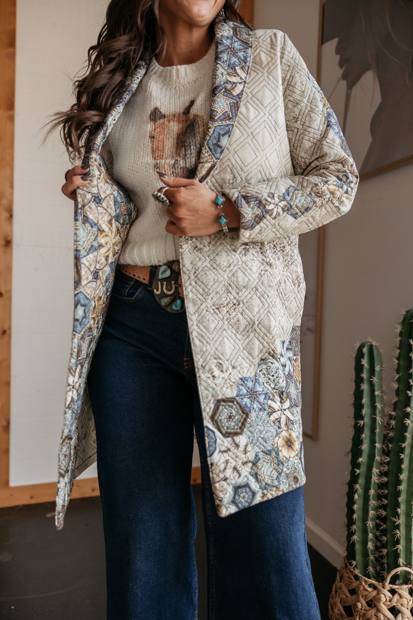 Woman in quilted western boho jacket, horse graphic sweater, and wide-leg jeans
