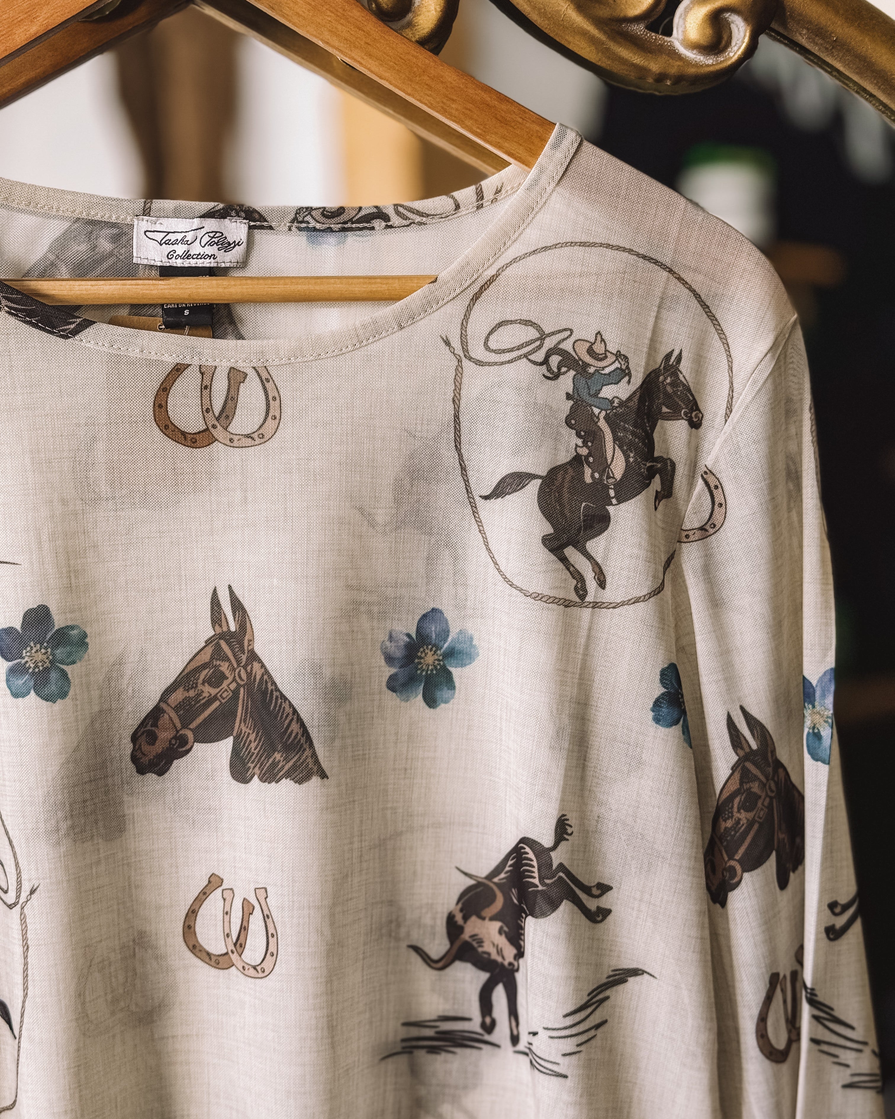 Thunderbird pendant chain necklace displayed on wooden slab with serape fabric underneath - The Wild J