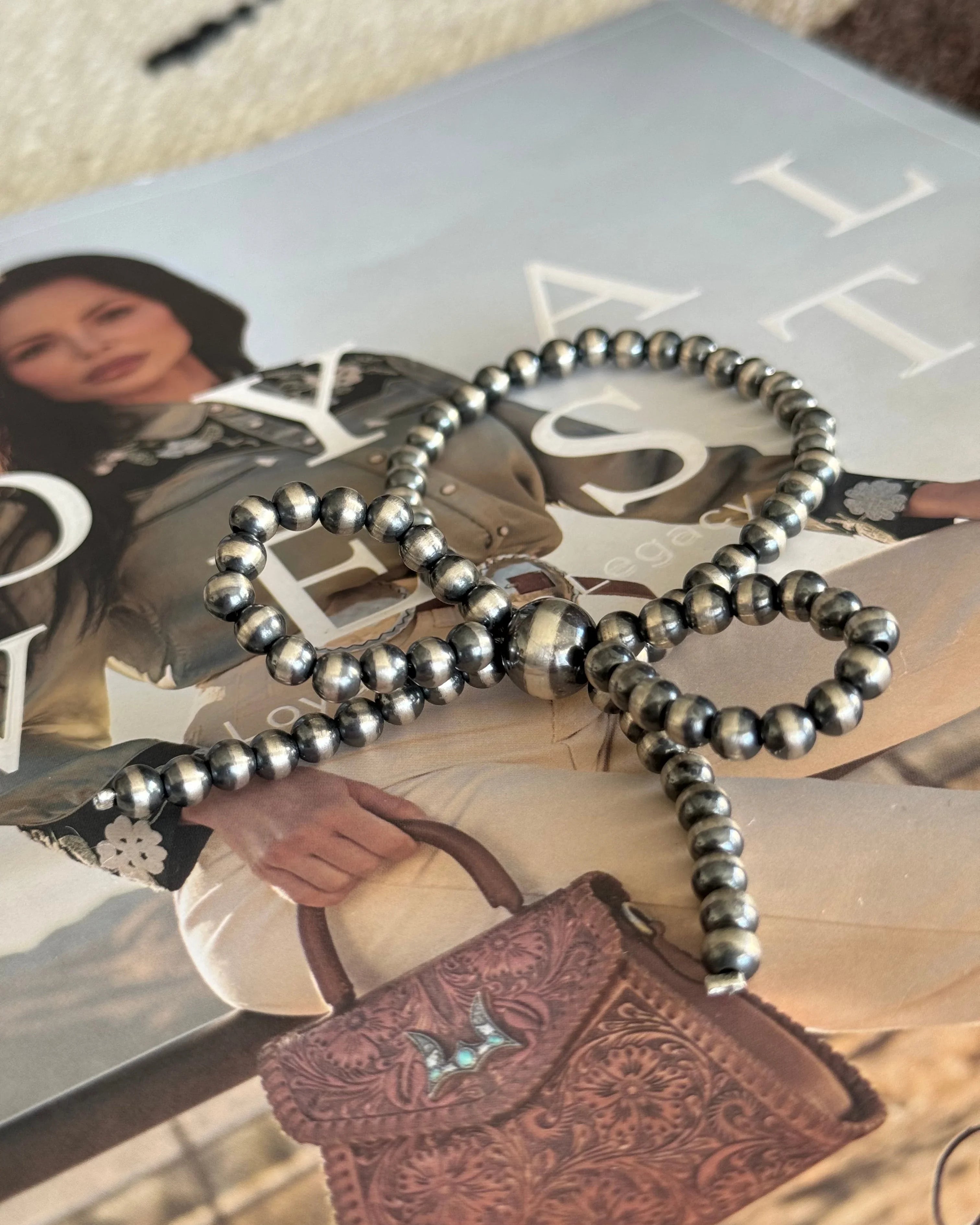 Thunderbird pendant chain necklace displayed on wooden slab with serape fabric underneath - The Wild J