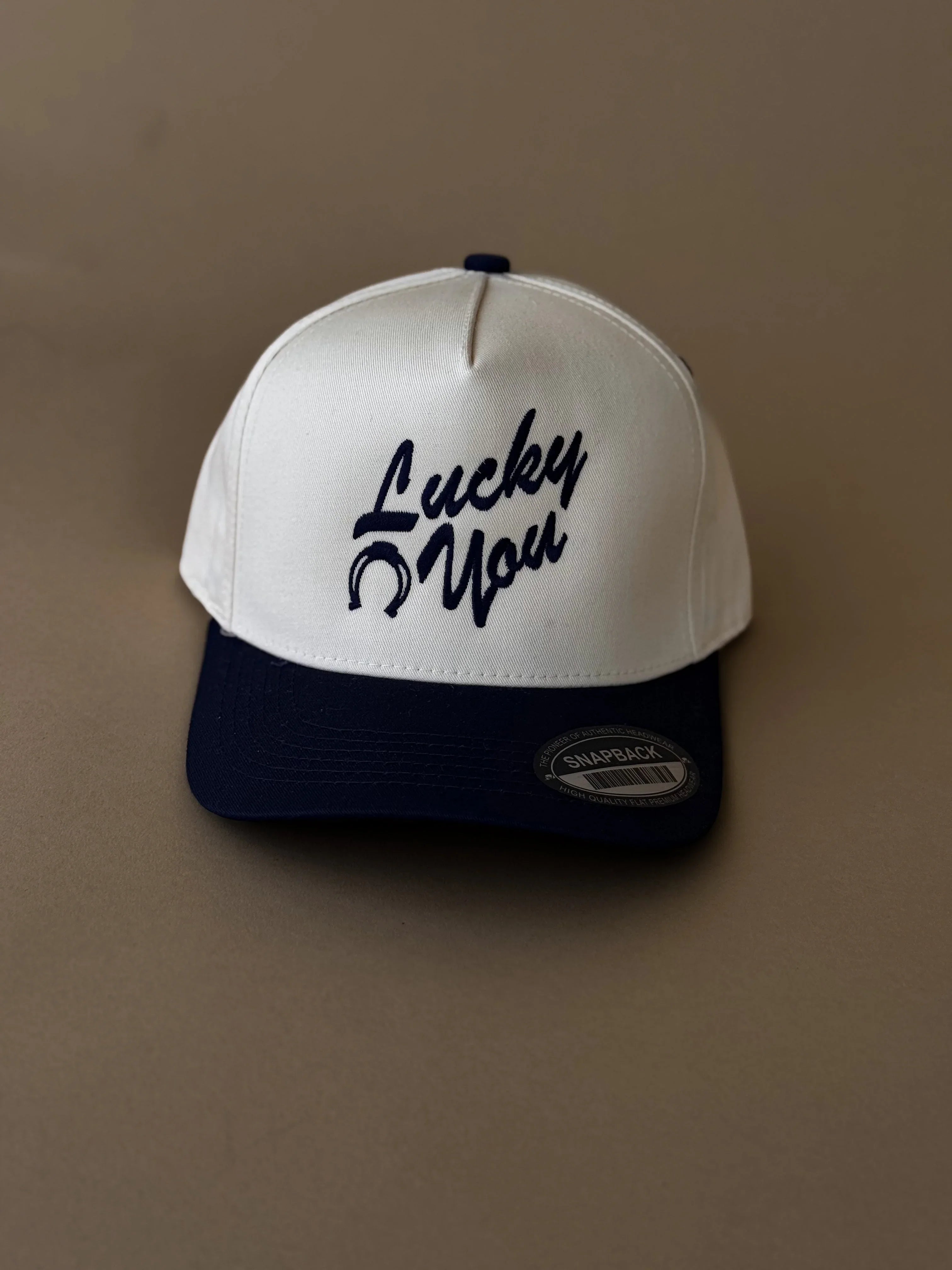 White and navy western snapback hat with 'Lucky You' and horseshoe embroidery