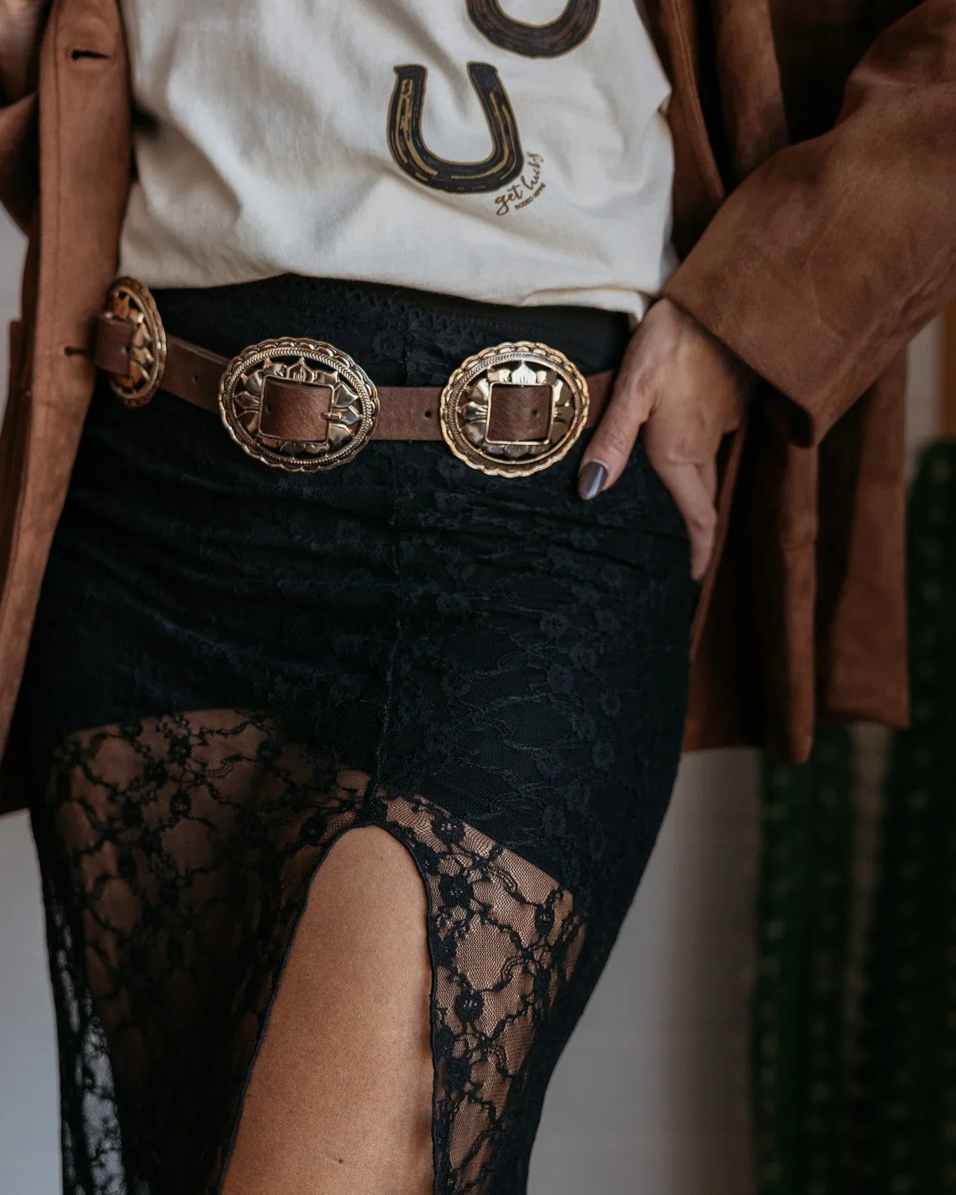 Western boho outfit with concho belt, lace skirt, and horseshoe graphic tee