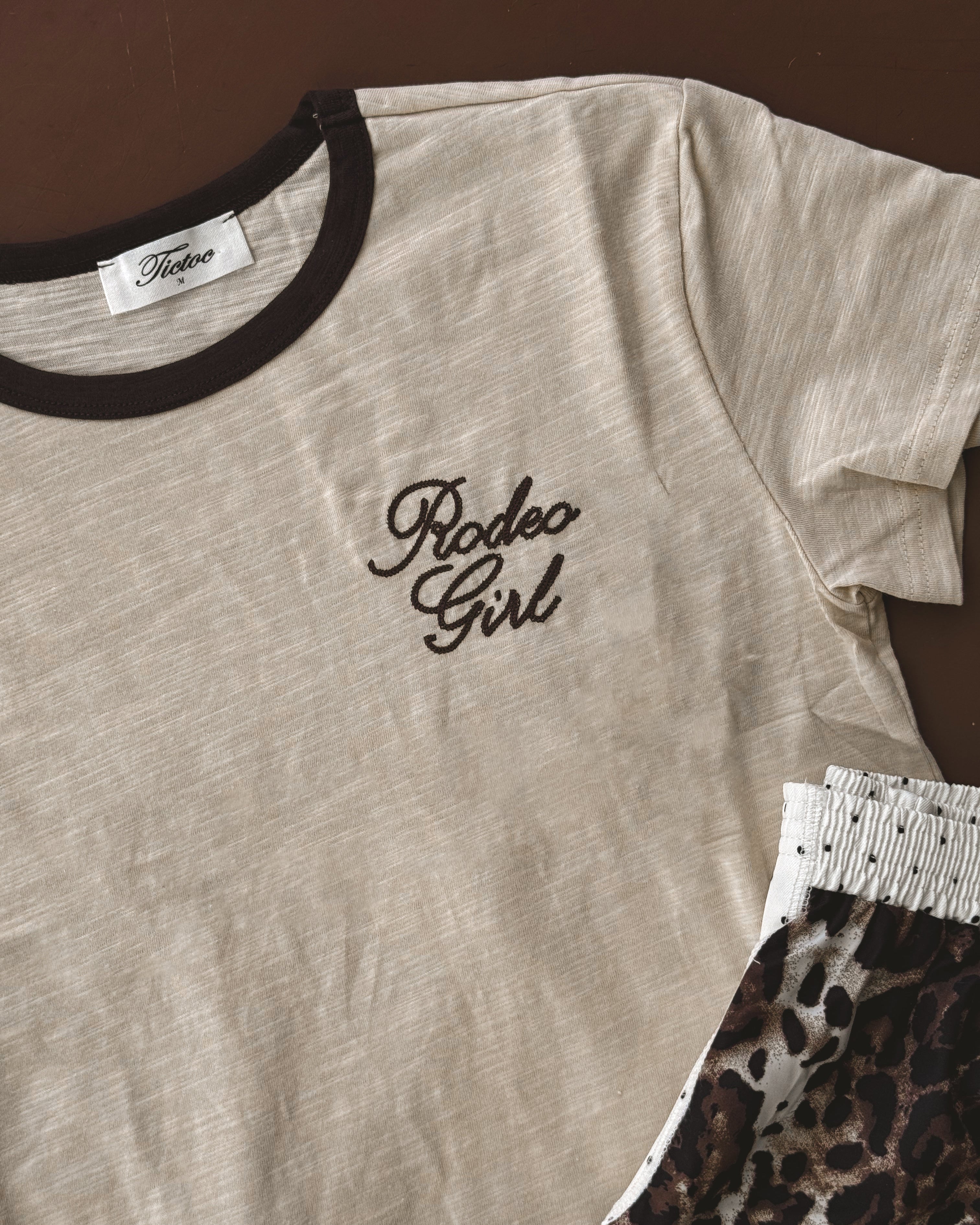 Beige Rodeo Girl ringer t-shirt with brown trim and leopard print shorts, western boho style.