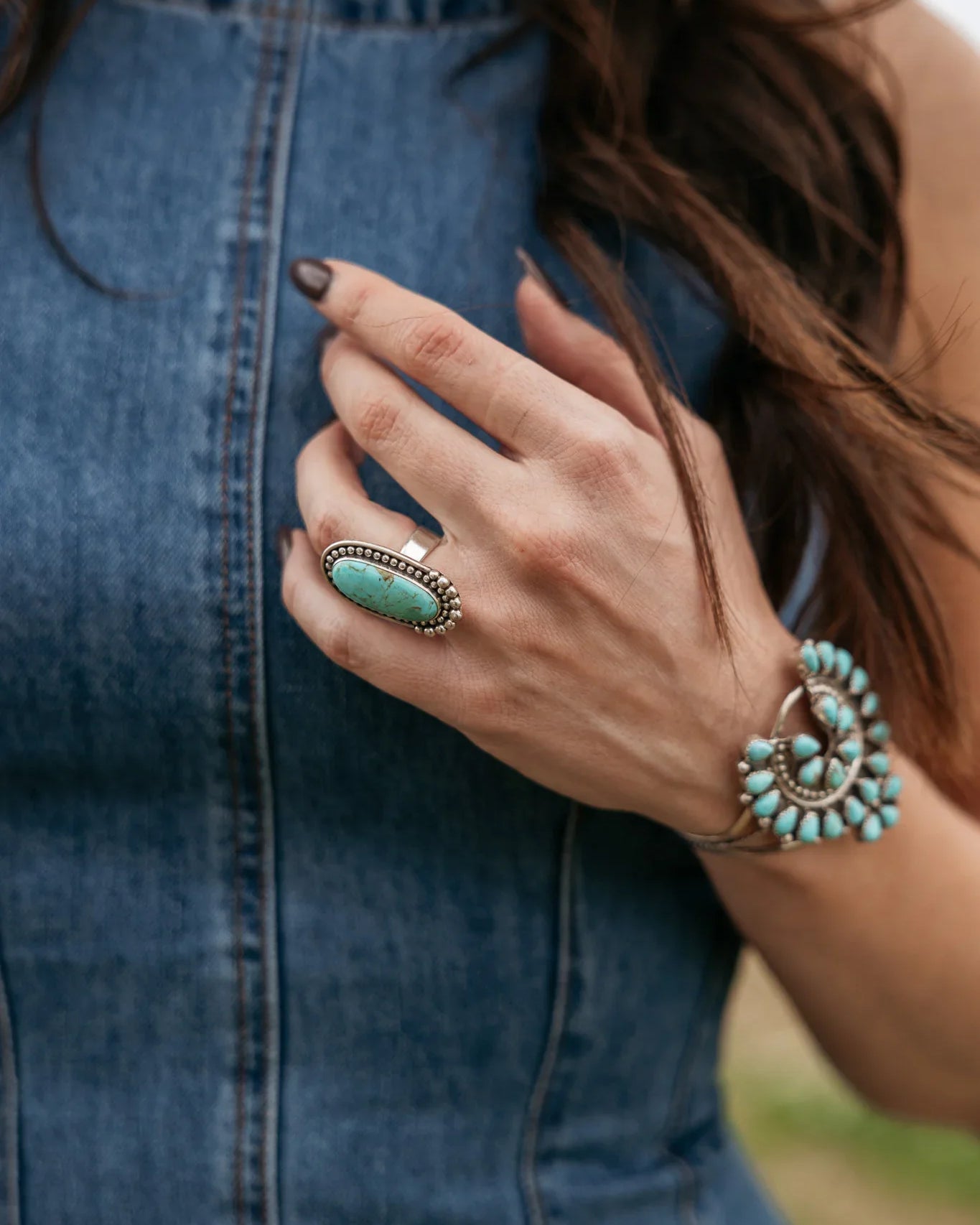 Woman wearing denim dress, turquoise statement ring and western turquoise bracelet