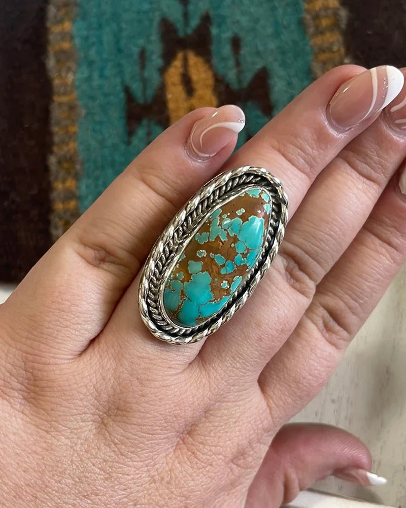 Hand wearing large oval turquoise and silver western boho statement ring