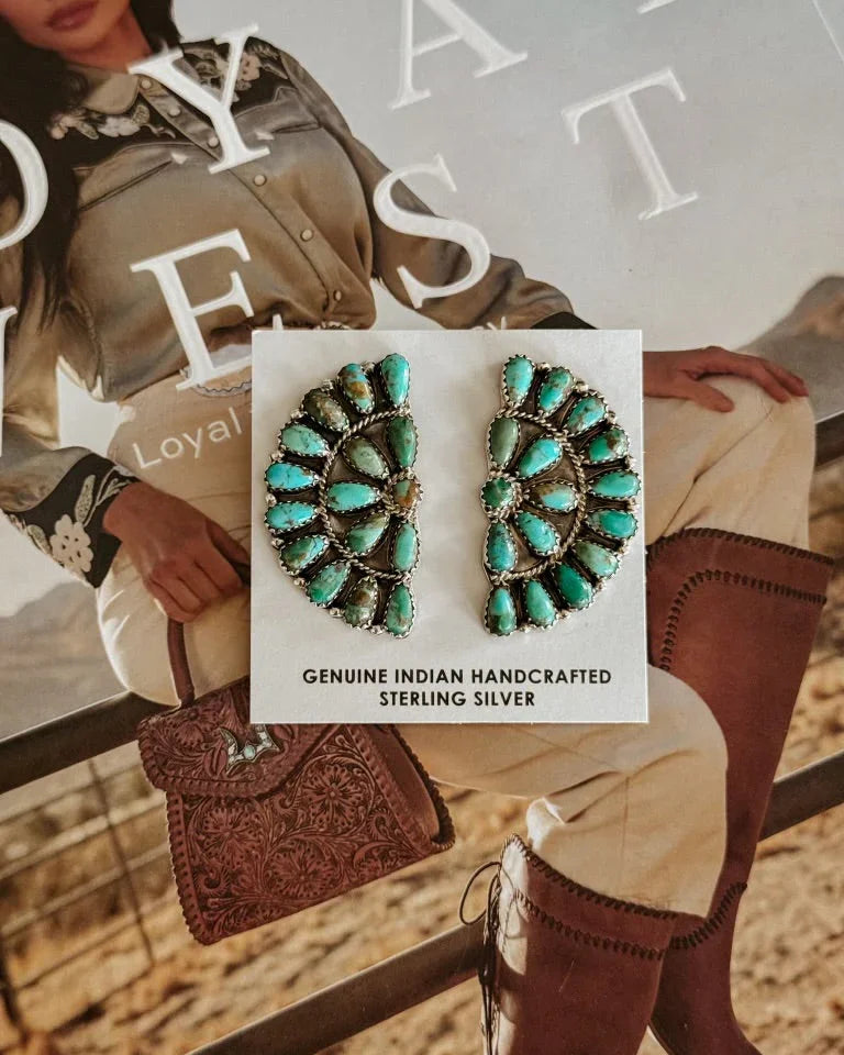 Turquoise sterling silver earrings, handcrafted, displayed on western fashion magazine with cowgirl boots.