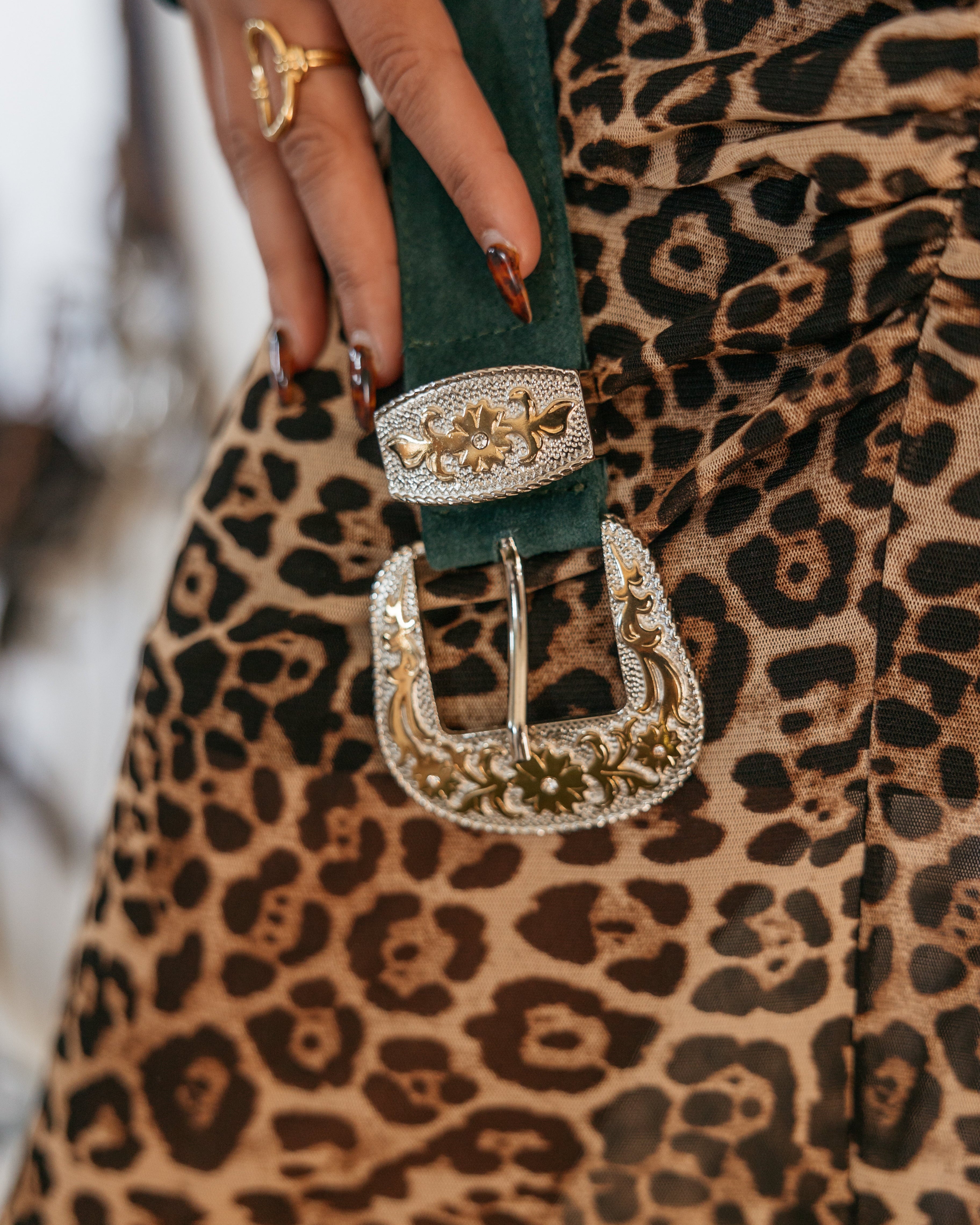 Western engraved belt buckle on green suede, paired with leopard print skirt