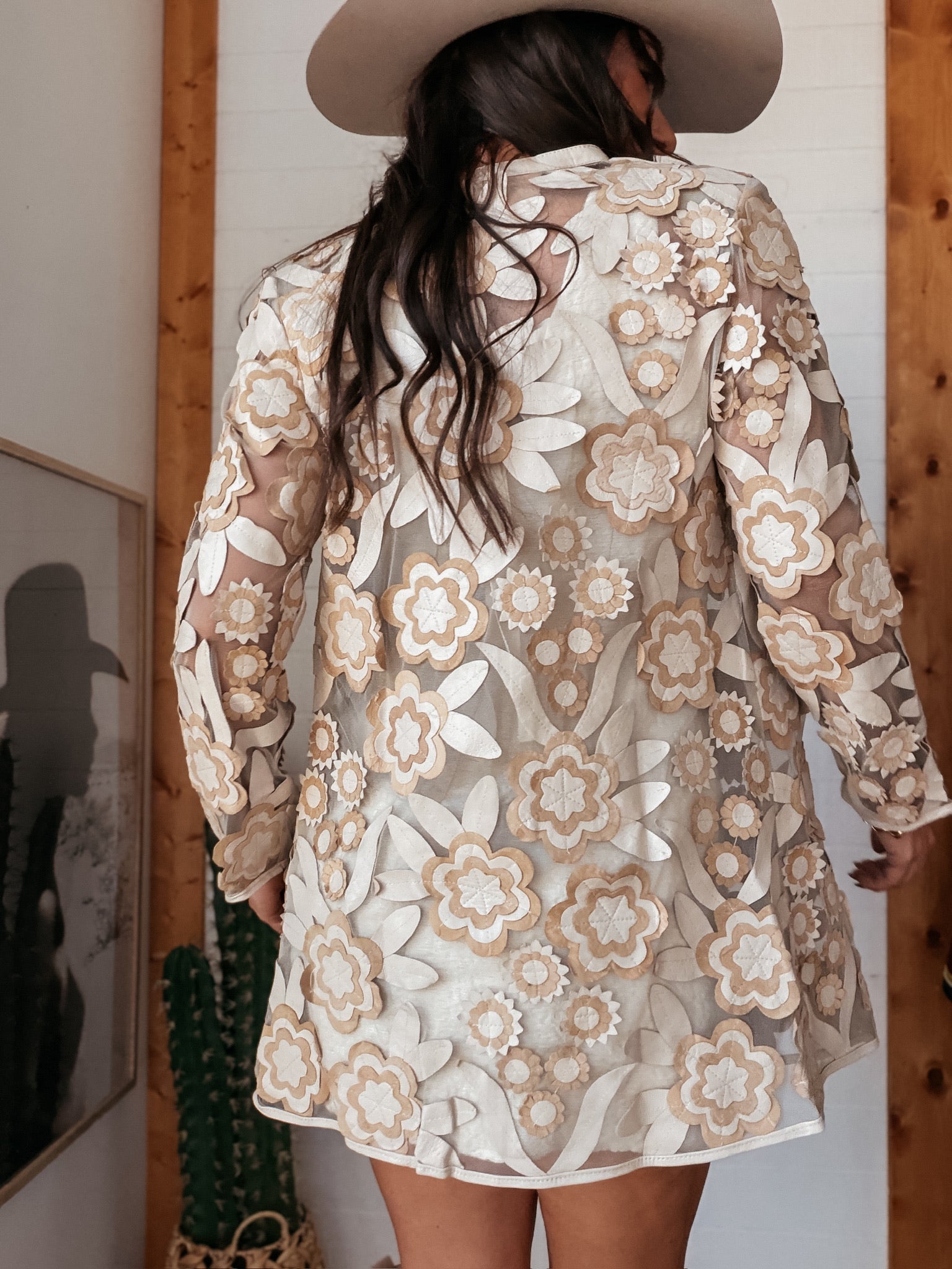 Woman in sheer floral western dress and felt hat, boho cowgirl outfit with neutral tones