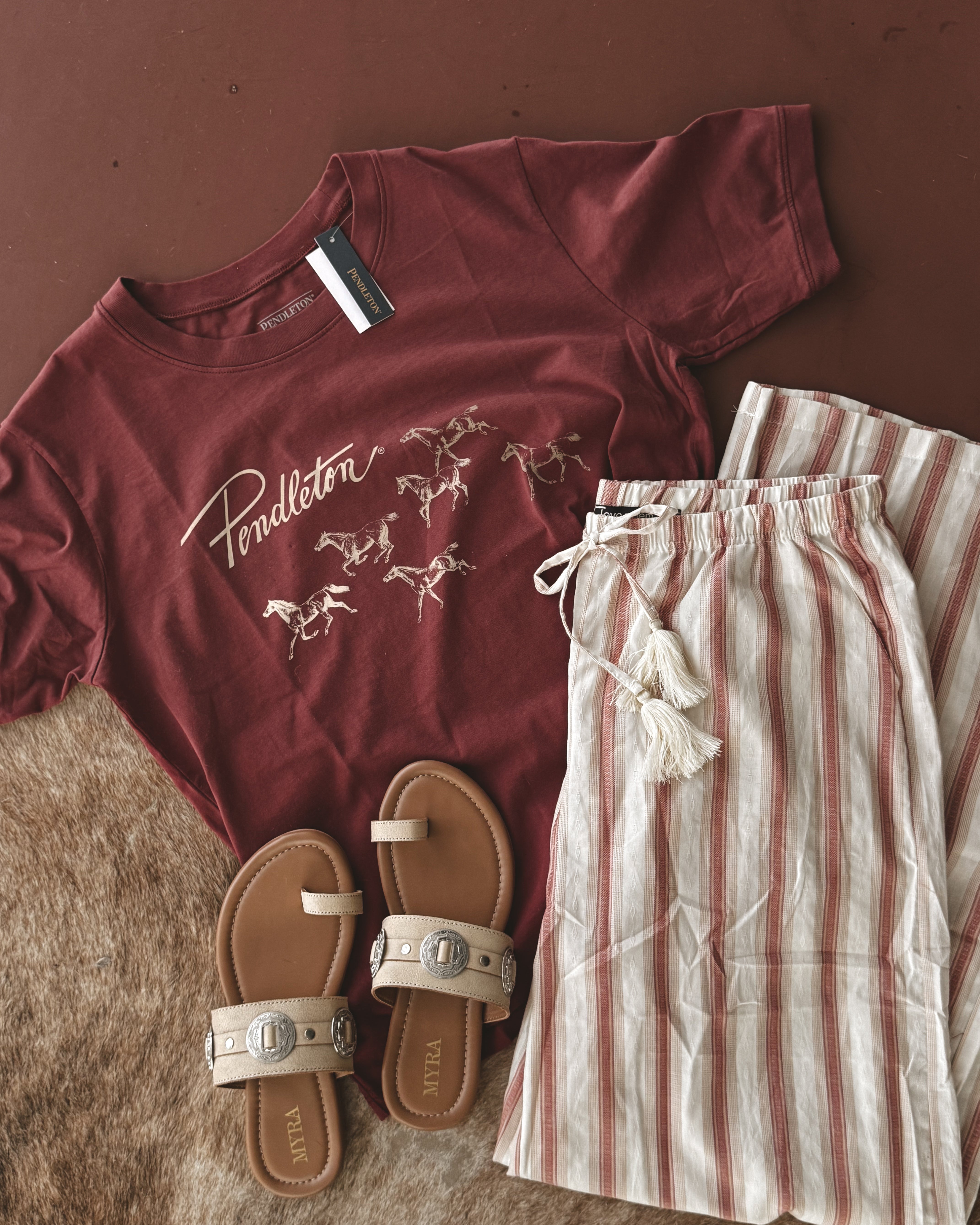 Thunderbird pendant chain necklace displayed on wooden slab with serape fabric underneath - The Wild J