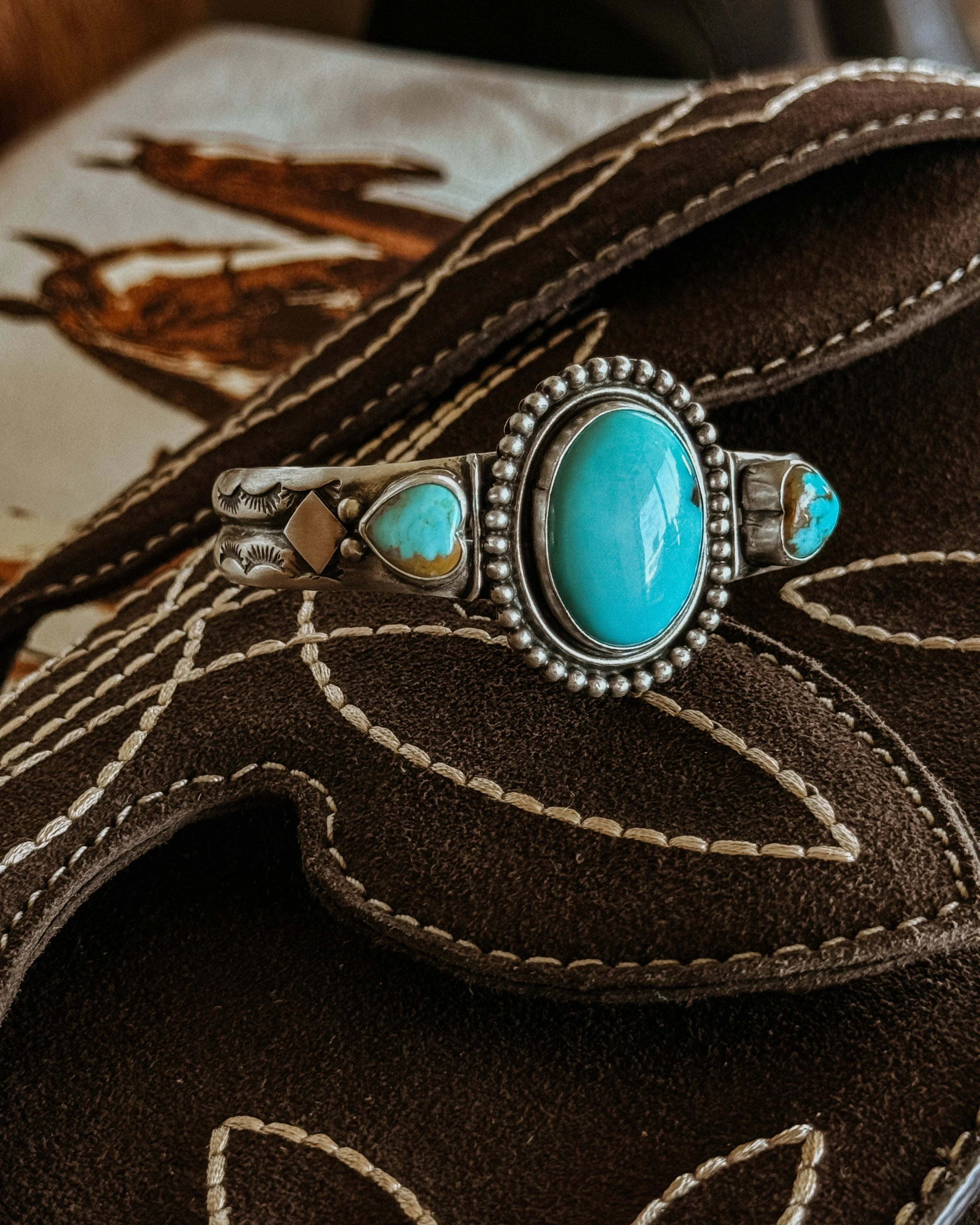 Turquoise and silver western bracelet on embroidered brown suede boot, cowgirl jewelry