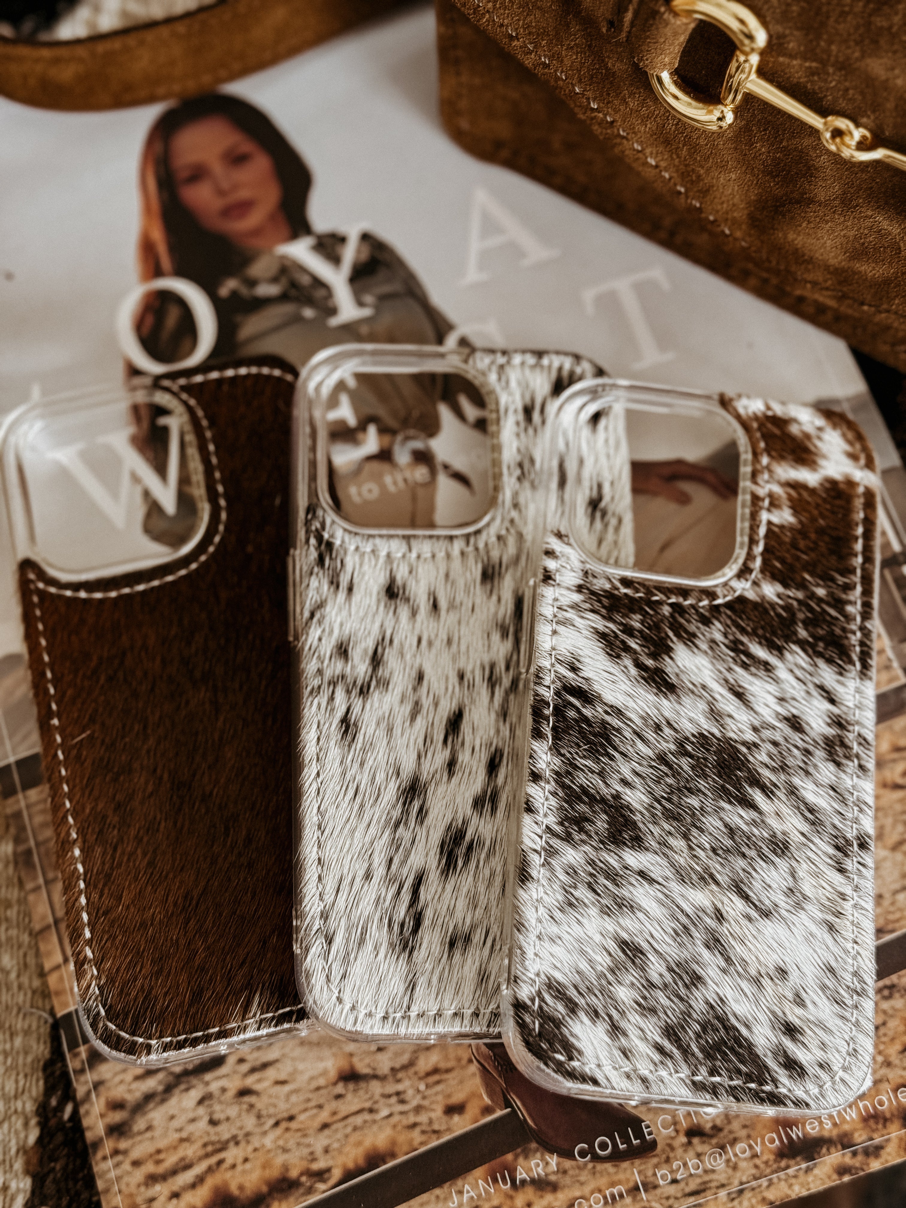 Cow print phone case on a magazine with a blurred background