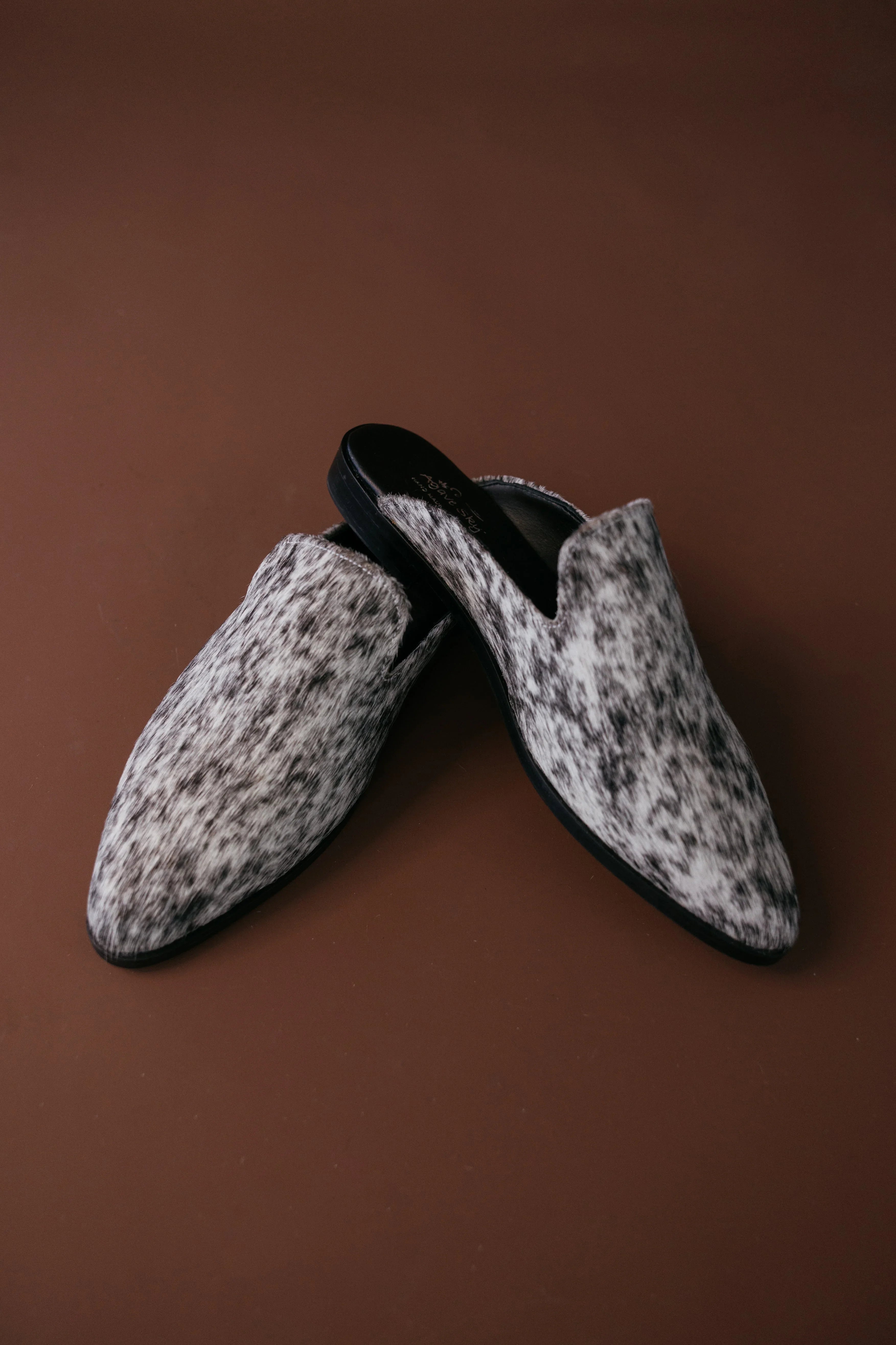 Pair of patterned slippers on a brown background
