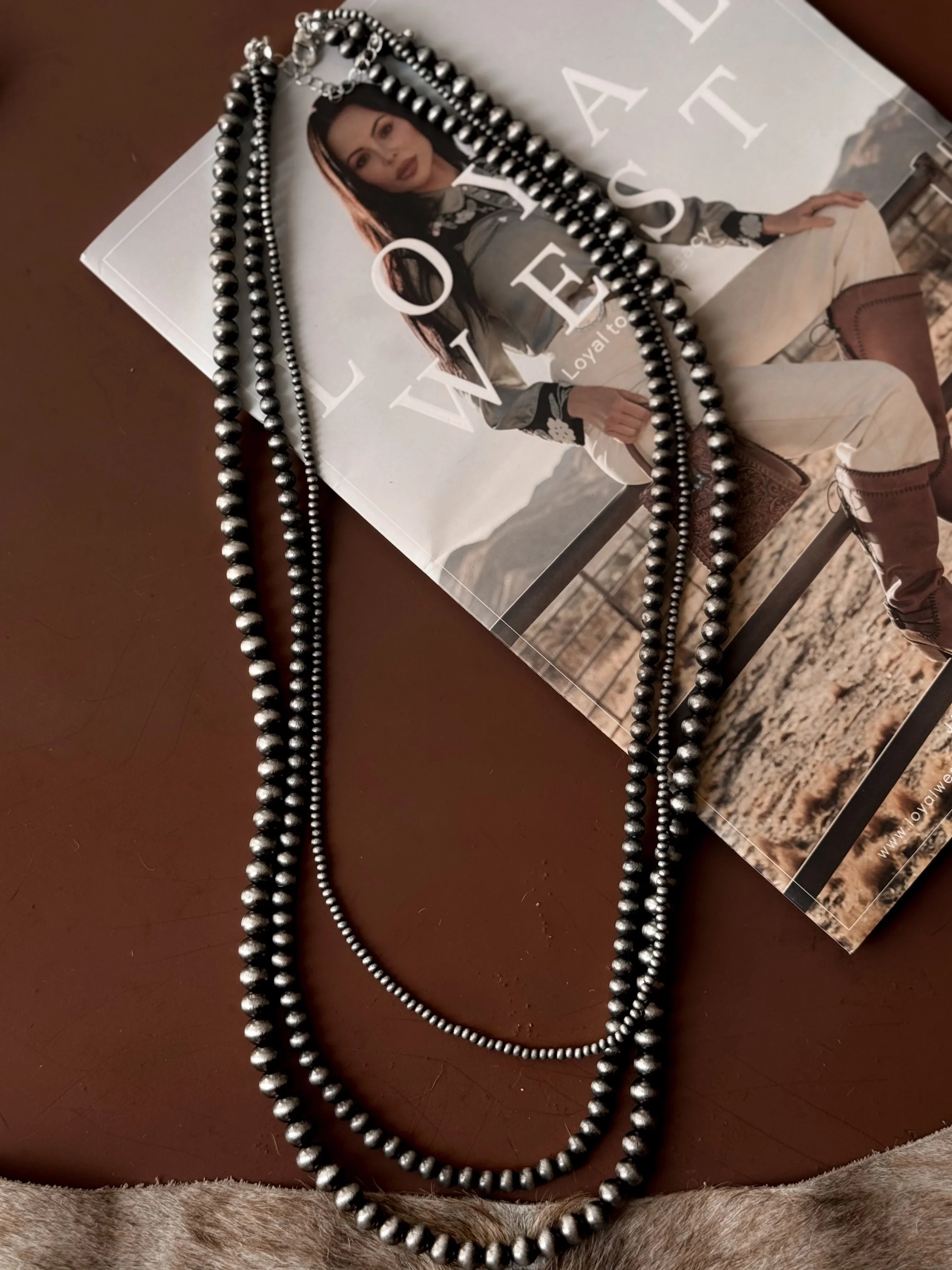 Long beaded necklace on a magazine with a woman on the cover