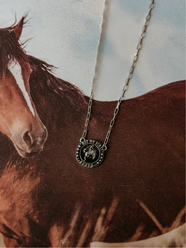Western boho rodeo necklace with cowboy charm and large chain links on horse photo background