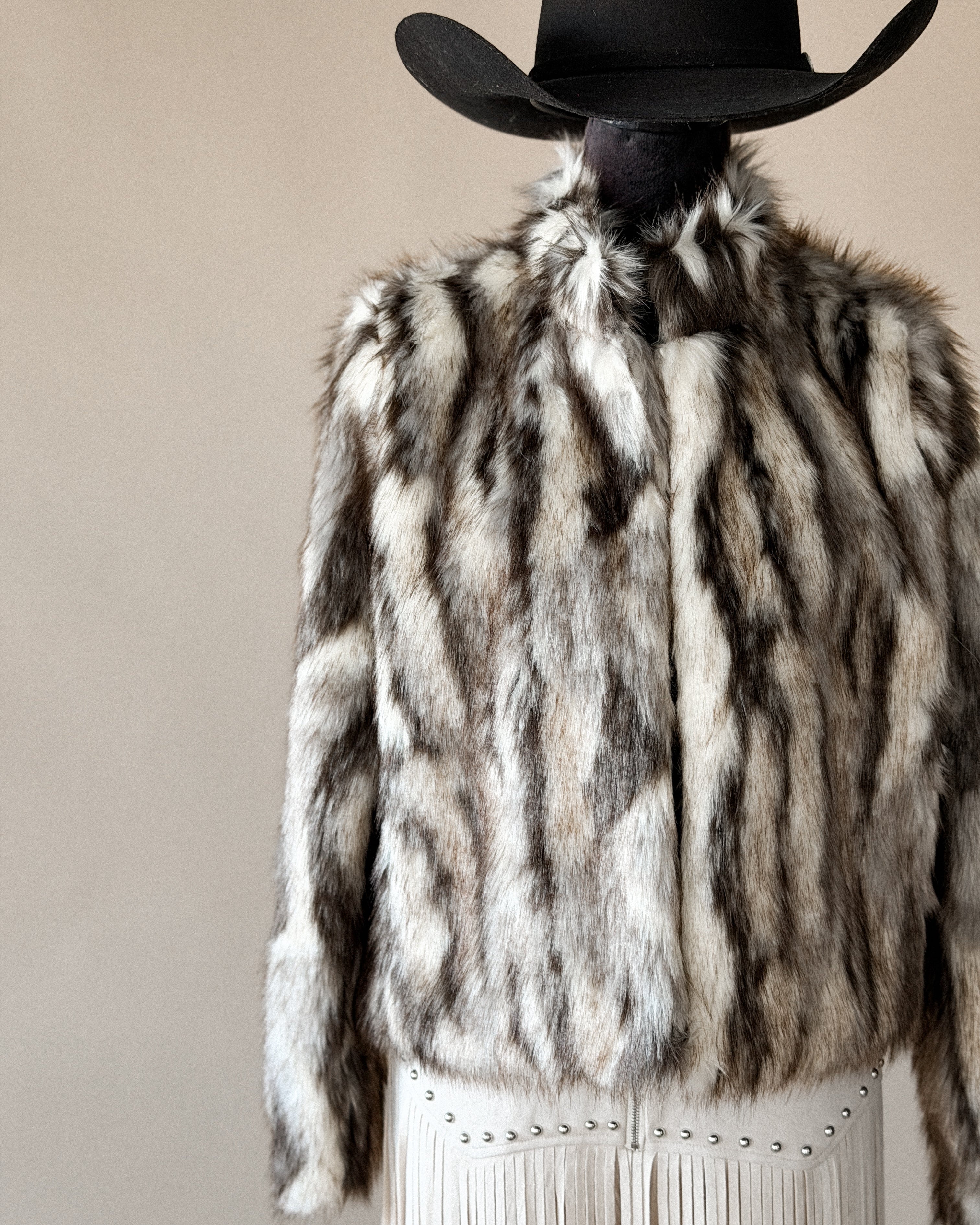 Western faux fur jacket with fringe skirt and black cowboy hat, boho cowgirl style