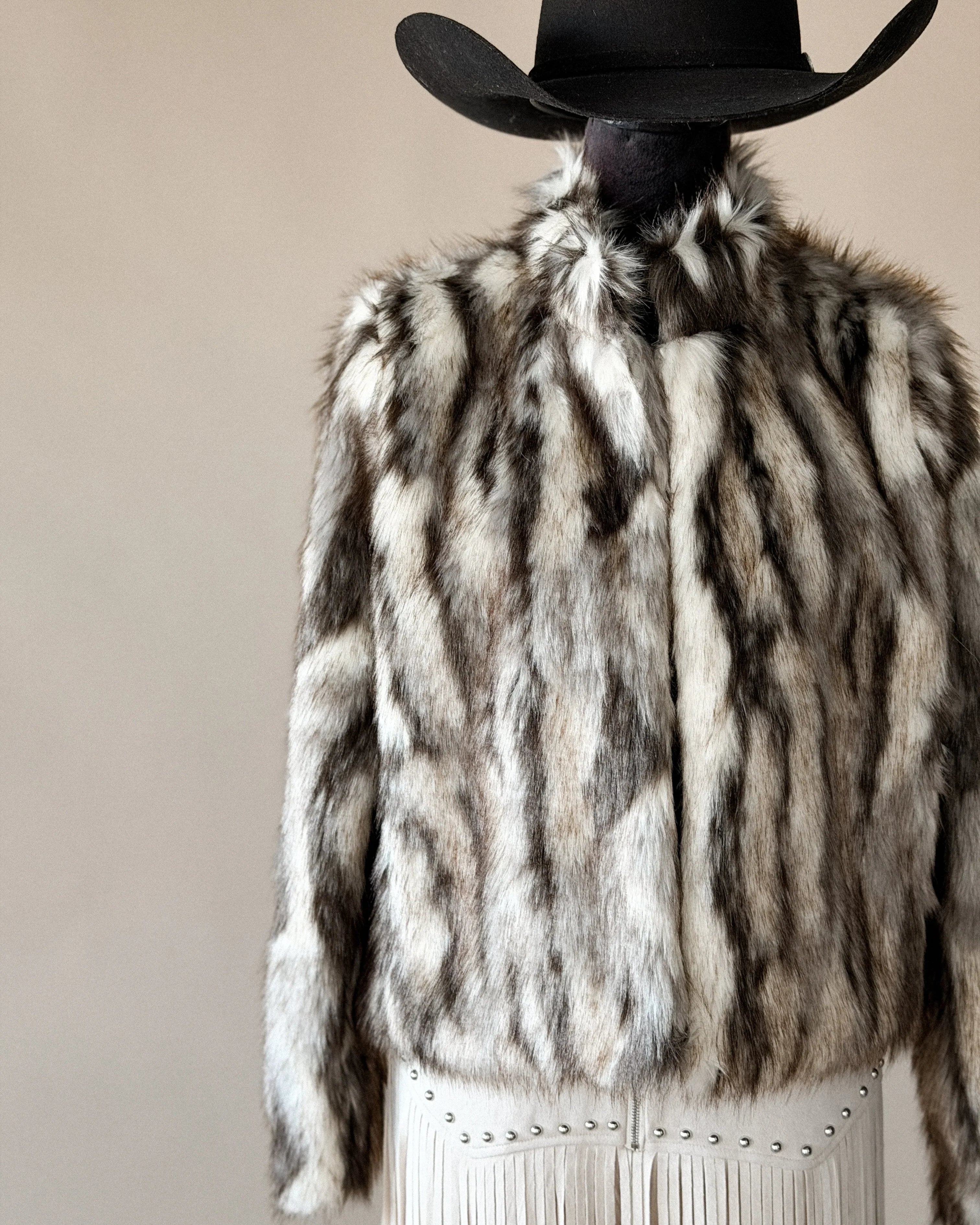 Western faux fur jacket with fringe skirt and black cowboy hat, boho cowgirl style