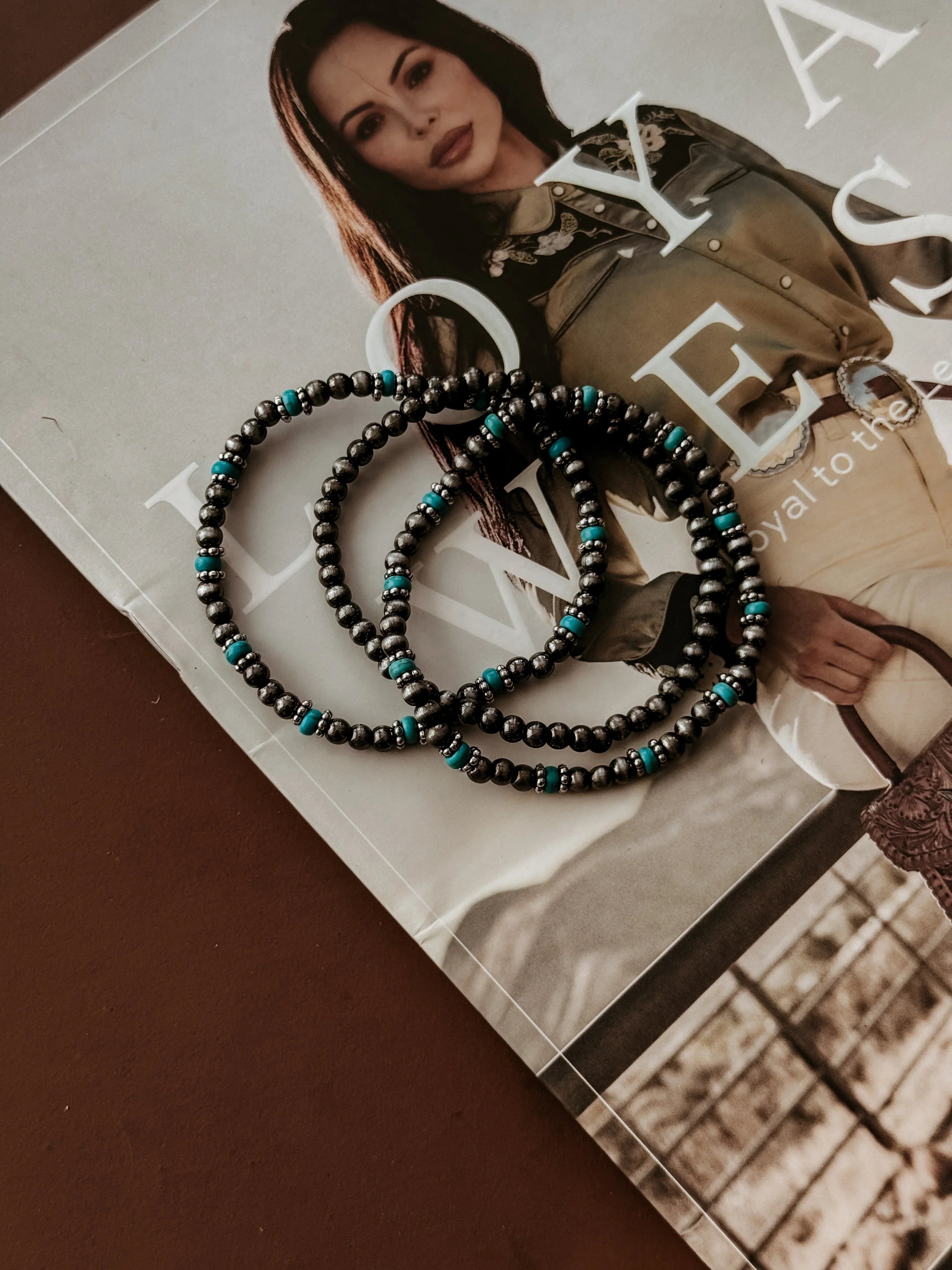 Three beaded necklaces with turquoise accents on a magazine
