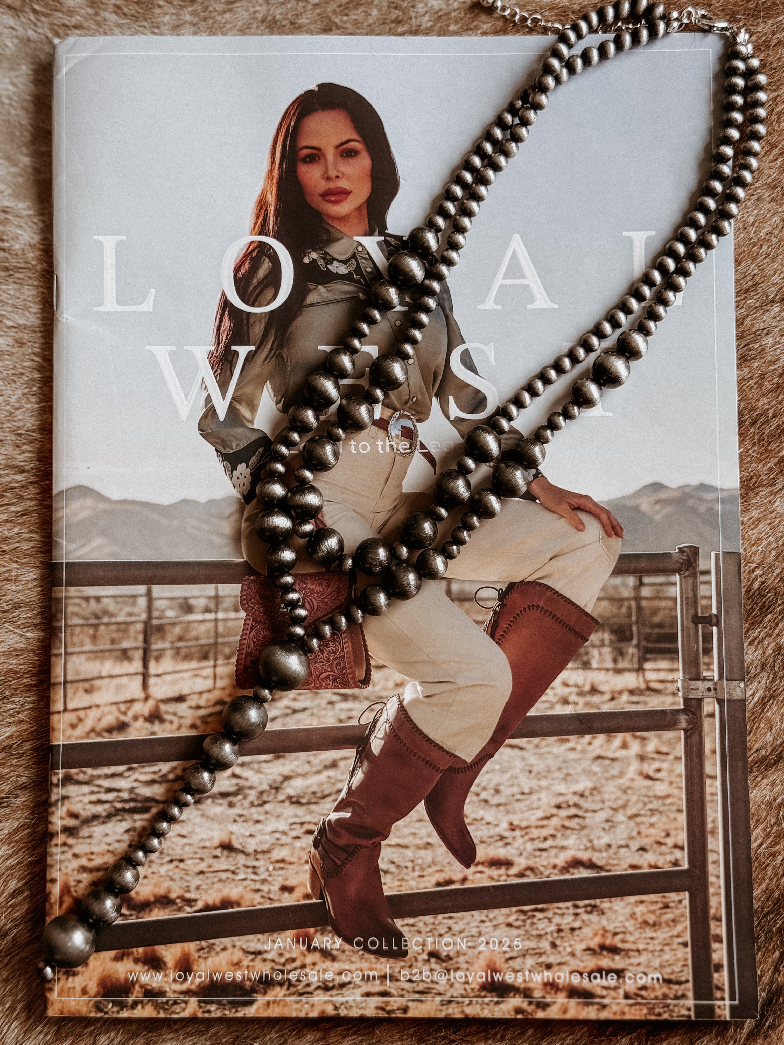 Thunderbird pendant chain necklace displayed on wooden slab with serape fabric underneath - The Wild J