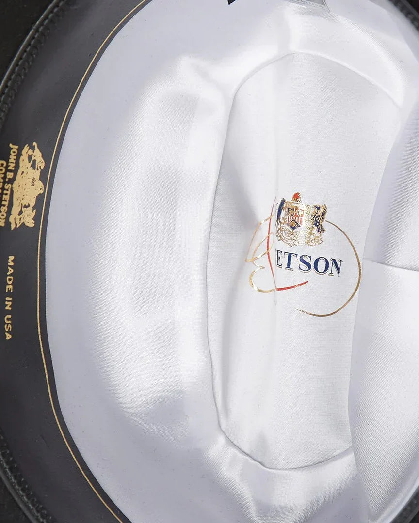 Close-up of the interior satin lining of a western cowboy hat with gold crest and USA marking