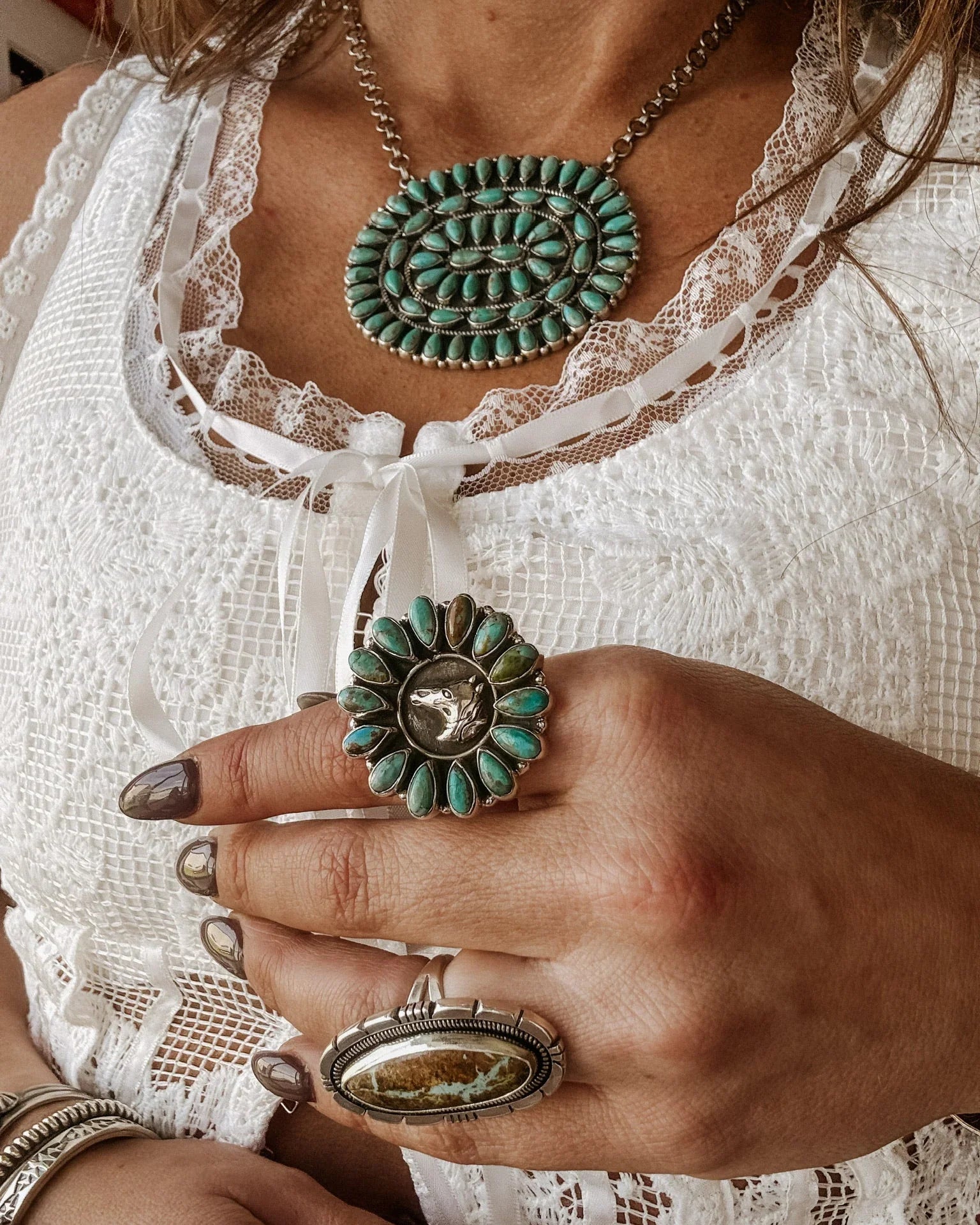 Cowgirl wearing a turquoise squash blossom necklace and large sterling silver horse ring